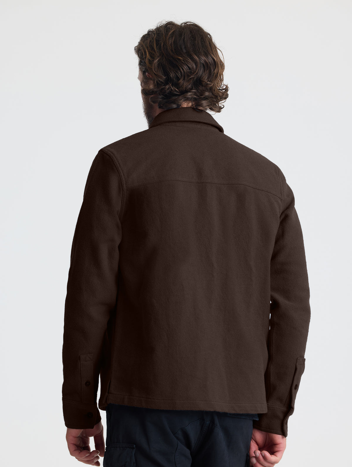 Rear upper-body view of man wearing the Pioneer Heavyweight Button-Down in Ash Brown from AETHER Apparel.
