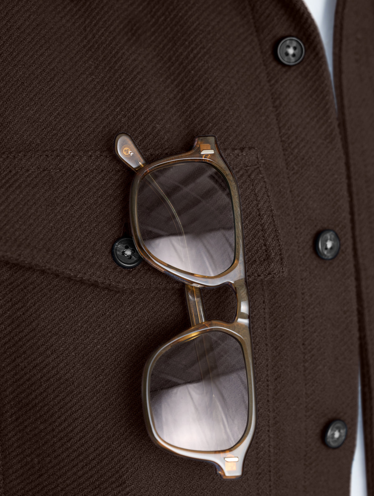 Closeup detailed view of the sunglasses holder behind the right chest pocket on the Pioneer Heavyweight Button-Down in Ash Brown from AETHER Apparel.