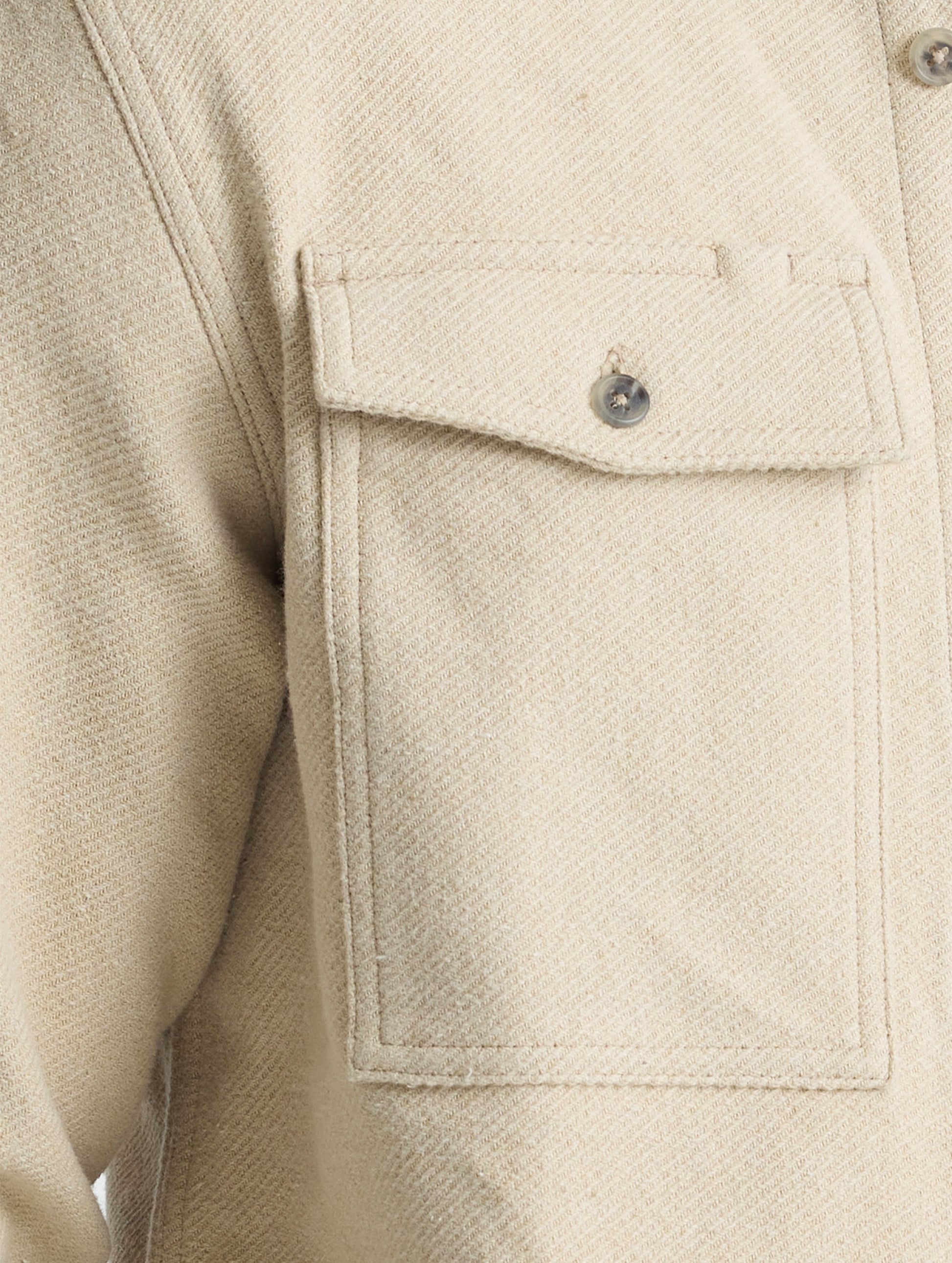 Closeup detailed view of the button-secured chest patch pockets on the Pioneer Heavyweight Button-Down in Bone white from AETHER Apparel.