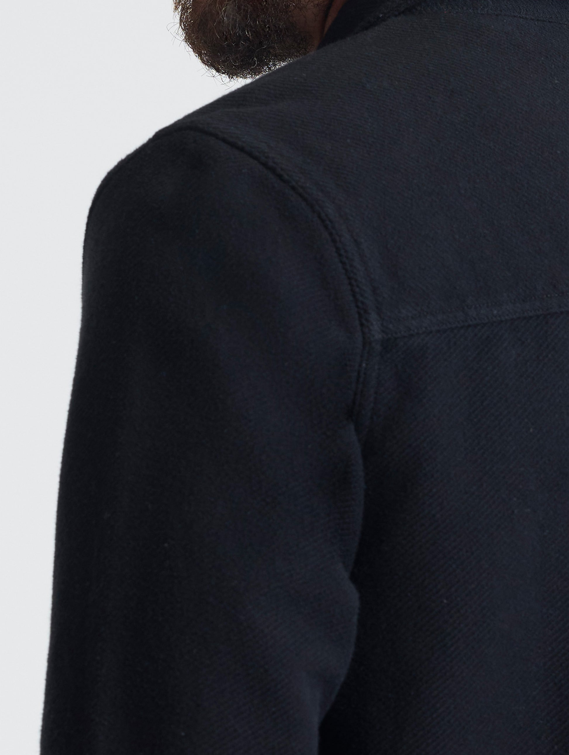 Closeup detailed view of the forward shoulder seams on the Pioneer Heavyweight Button-Down in Onyx Black from AETHER Apparel.