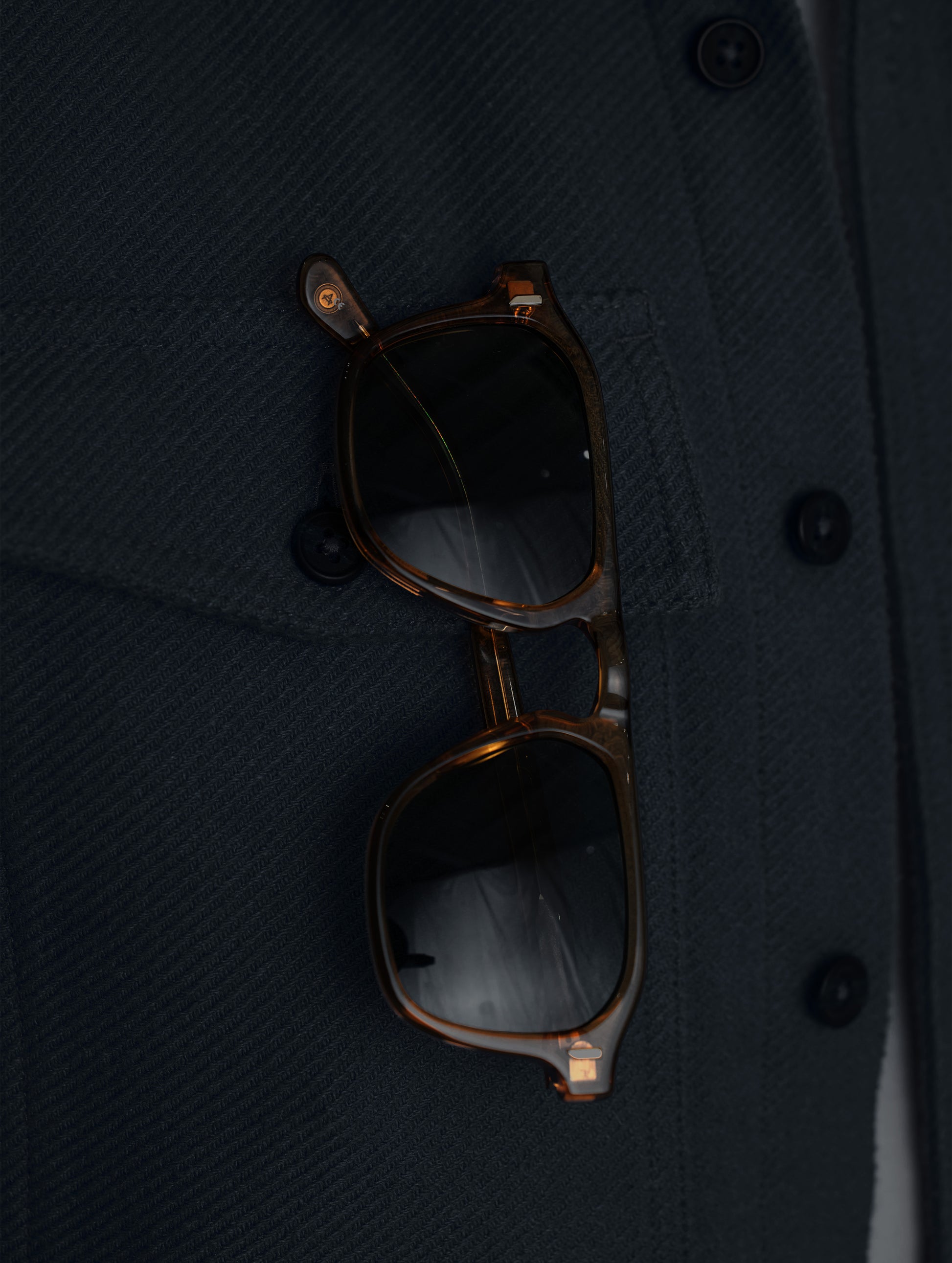 Closeup detailed view of the sunglasses slip behind the right patch pocket on the Pioneer Heavyweight Button-Down in Onyx Black from AETHER Apparel.