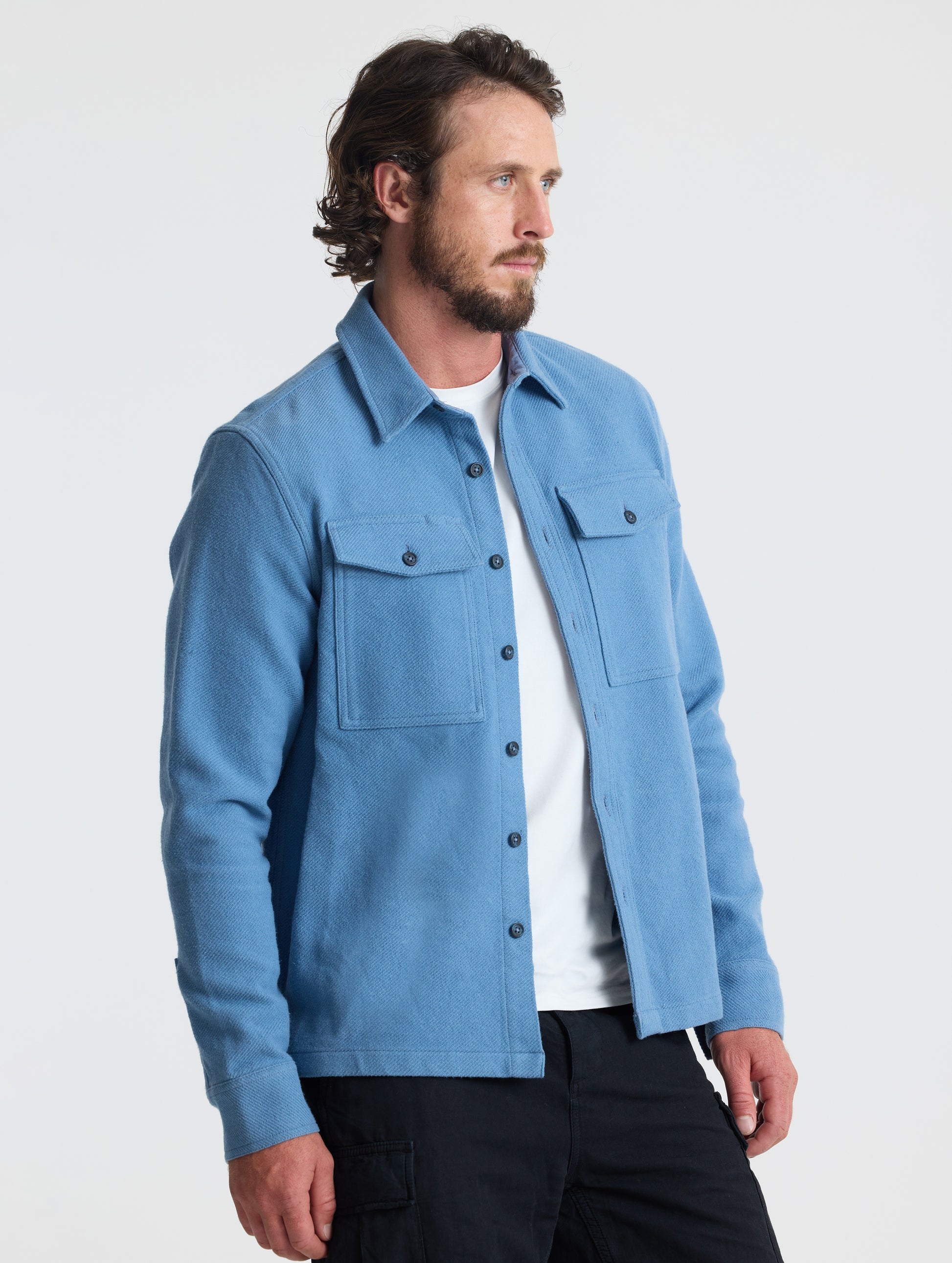 Front, angled upper-body view of man wearing Pioneer Heavyweight Button-Down in Portal Blue from AETHER Apparel.