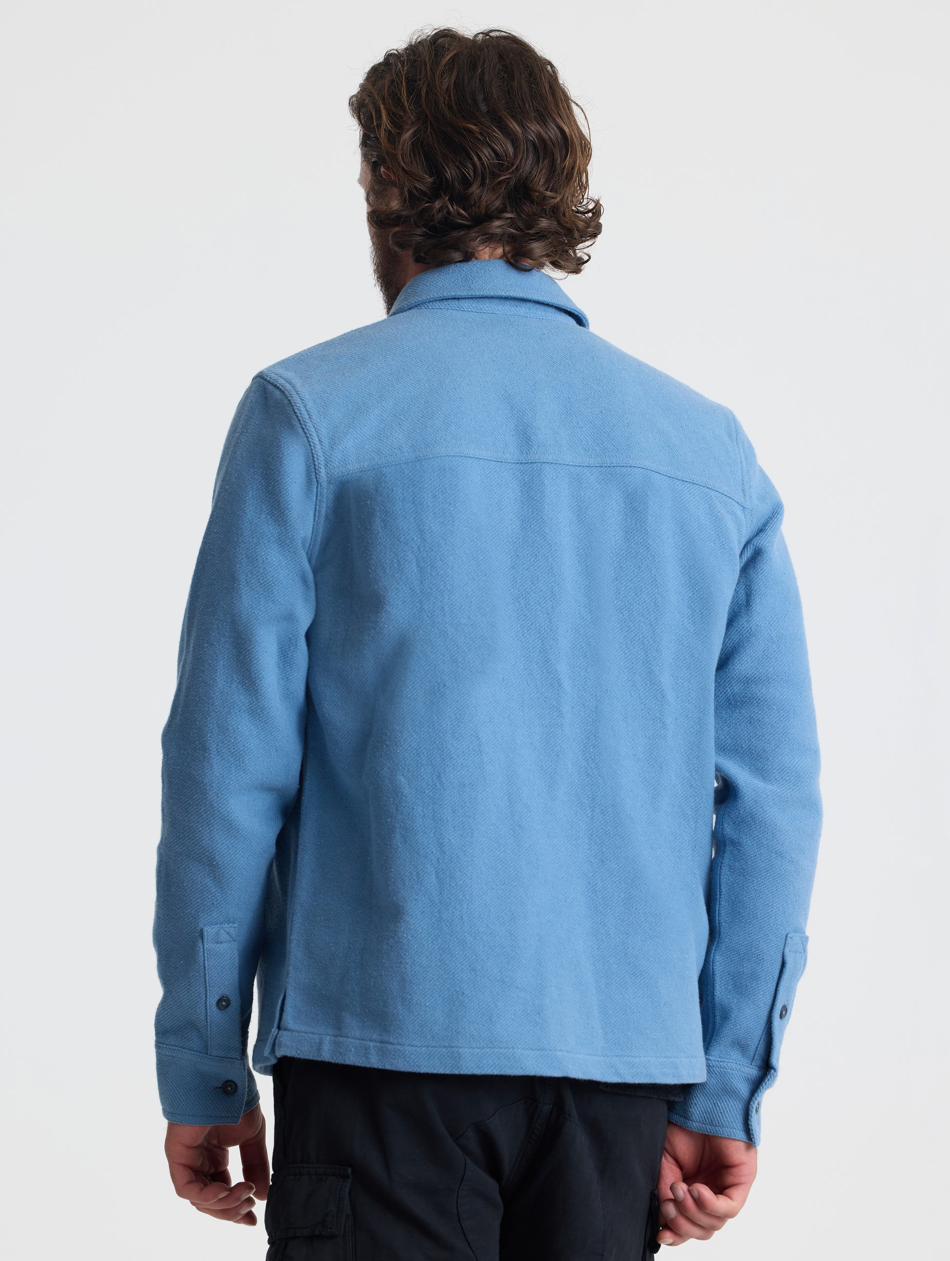 Rear upper-body view of man wearing Pioneer Heavyweight Button-Down in Portal Blue from AETHER Apparel.