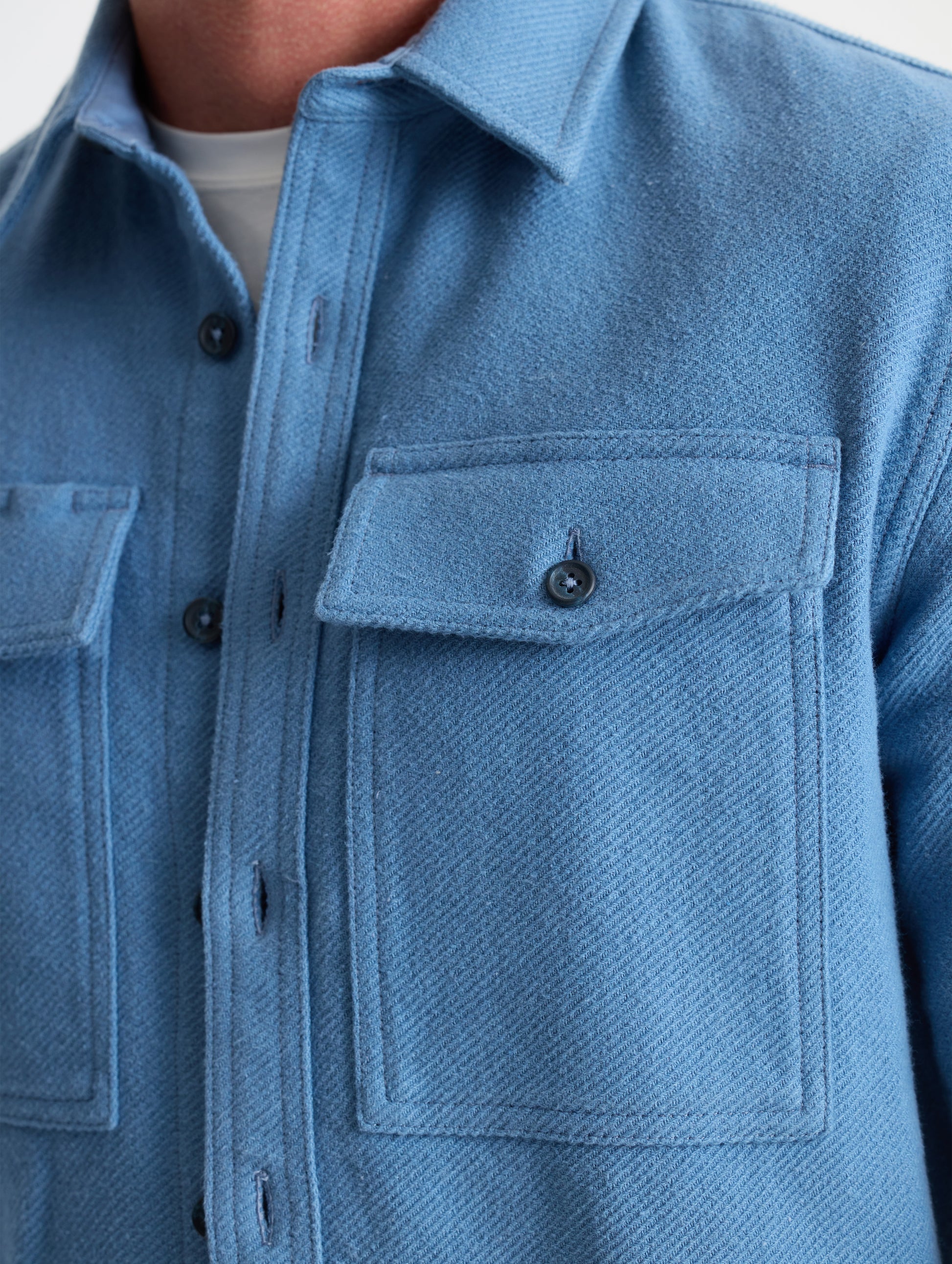 Closeup detailed view of the button-secured chest patch pockets on the Pioneer Heavyweight Button-Down in Portal Blue from AETHER Apparel.