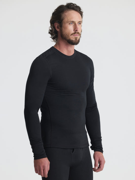 Front angled upper-body view of man wearing Polar Base Layer Crew in Onyx Black from AETHER Apparel.