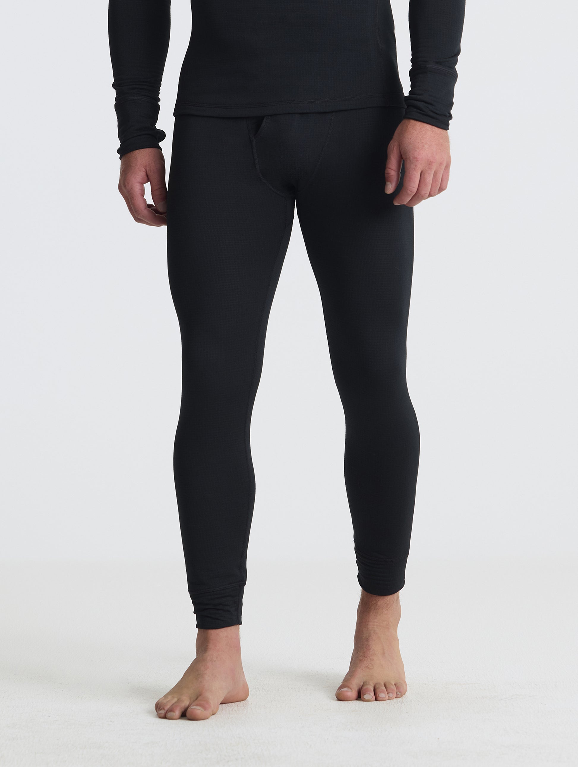 Front angled lower-body view of man wearing the Polar Base Layer Pant in Onyx Black from AETHER Apparel.