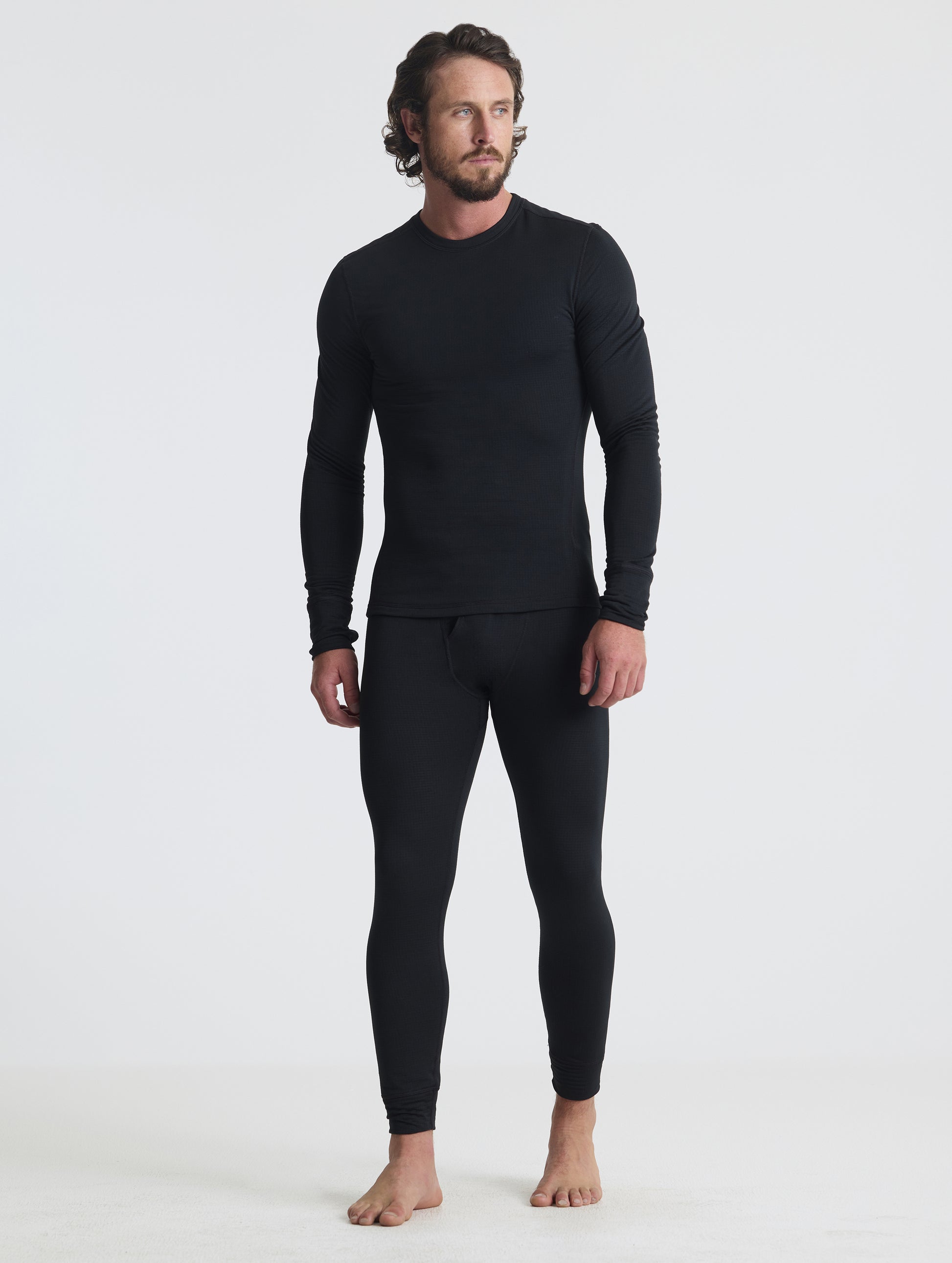 Front full-body view of man wearing the Polar Base Layer Pant in Onyx Black from AETHER Apparel.
