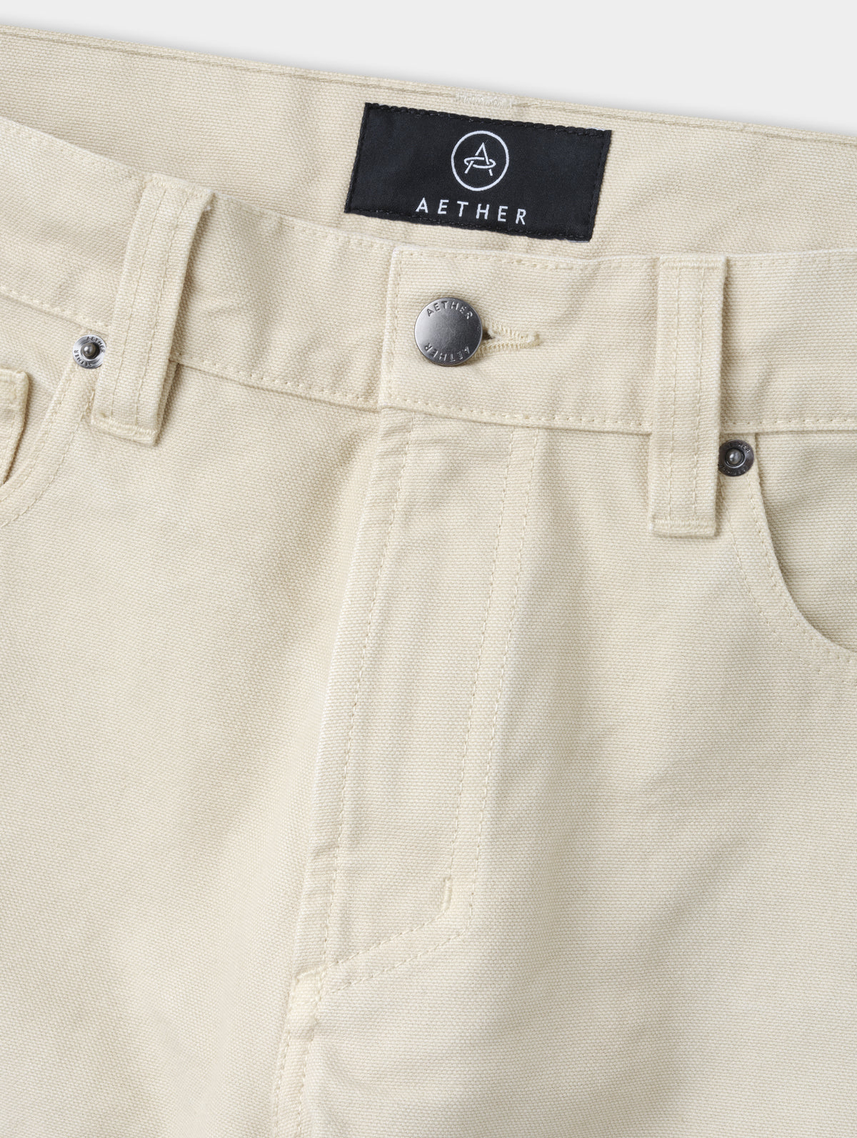 Closeup detailed view of the zippered fly and metal shank button closure on the Porter 5-Pocket Pant in Bone from AETHER Apparel.