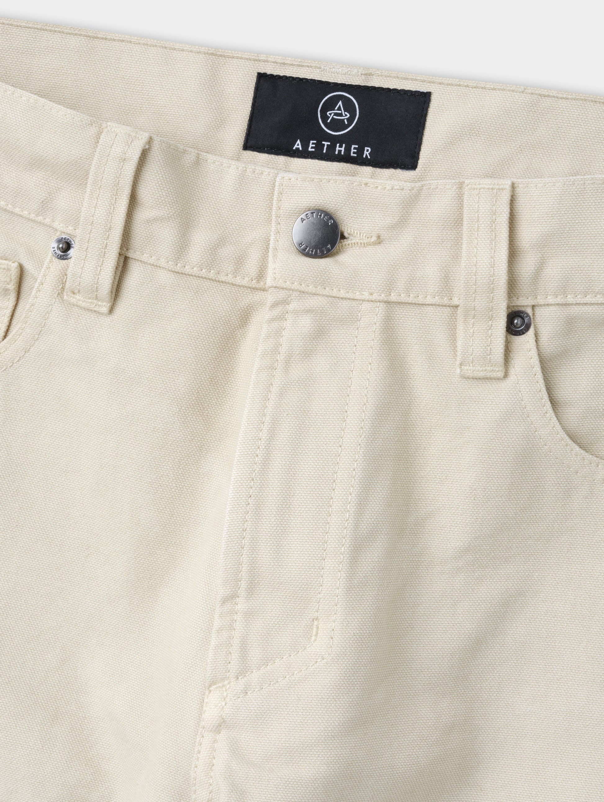 Closeup detailed view of the zippered fly and metal shank button closure on the Porter 5-Pocket Pant in Bone from AETHER Apparel.