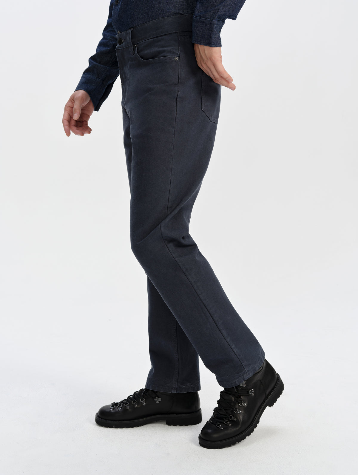 Side profile lower-body view of man wearing the Porter 5-Pocket Pant in Graphite from AETHER Apparel.