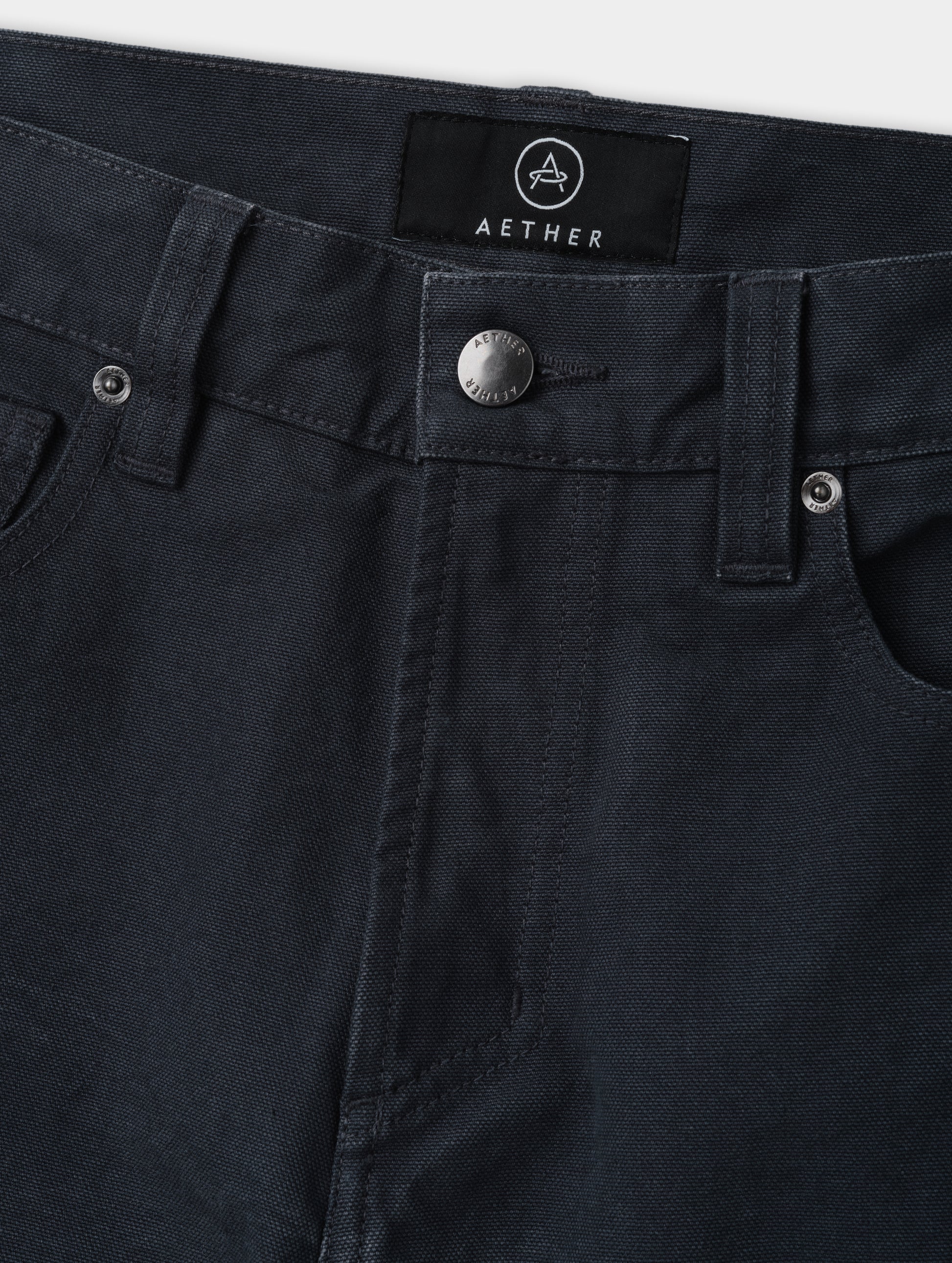 Closeup detailed view of the zippered fly and metal shank button closure on the Porter 5-Pocket Pant in Graphite from AETHER Apparel.