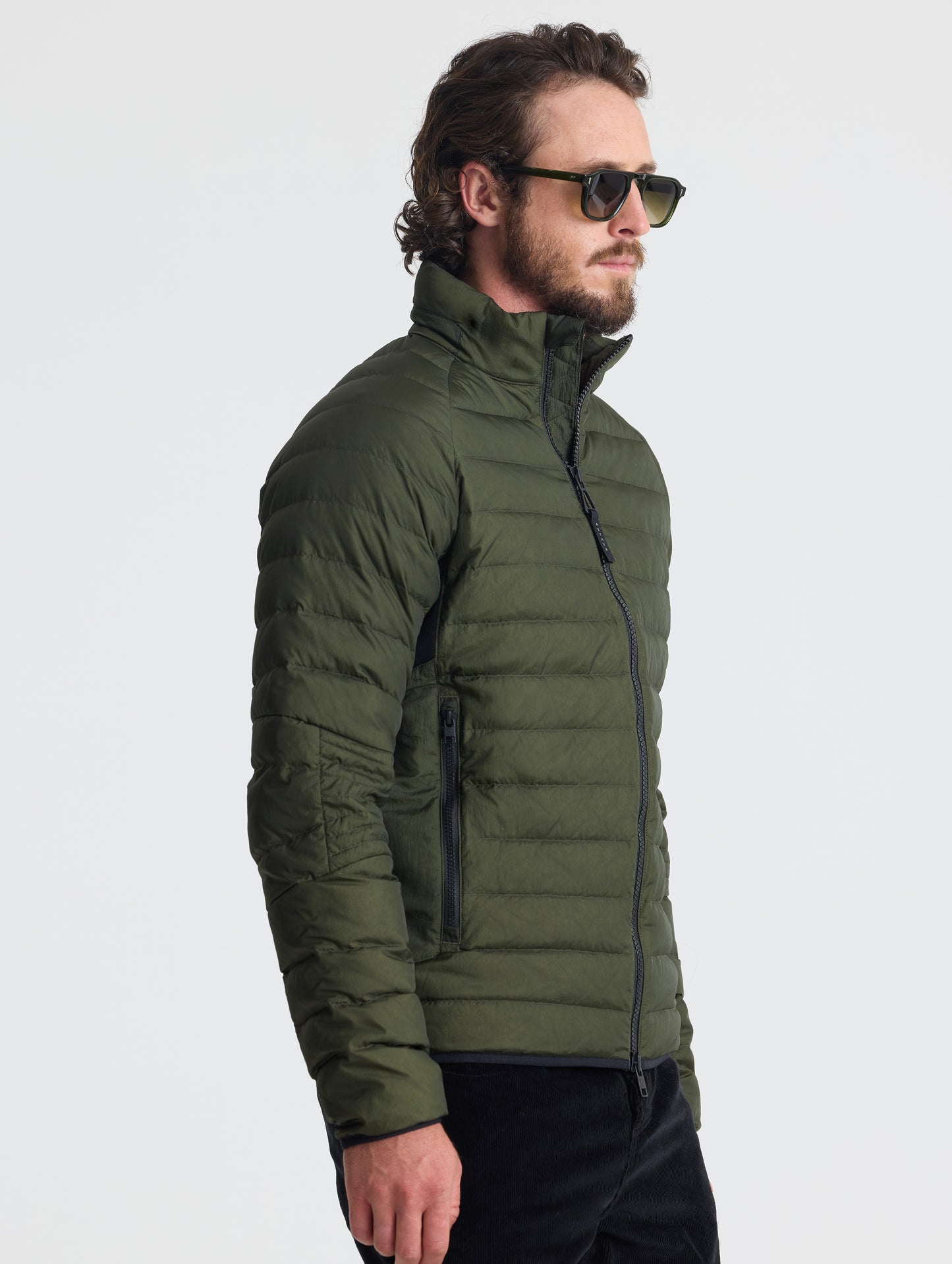 Angled view of man wearing Prospect Packable Down Jacket in Forest Green from AETHER Apparel.