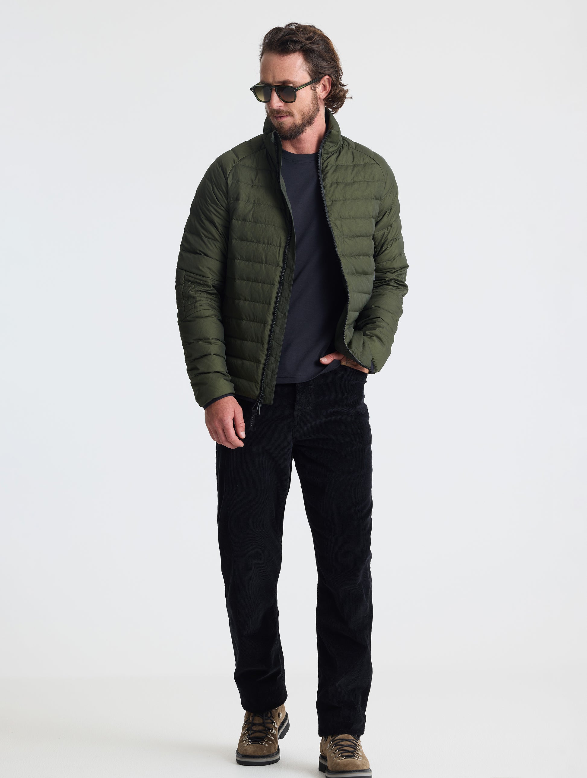 Full body view of man wearing Prospect Packable Down Jacket in Forest Green from AETHER Apparel.