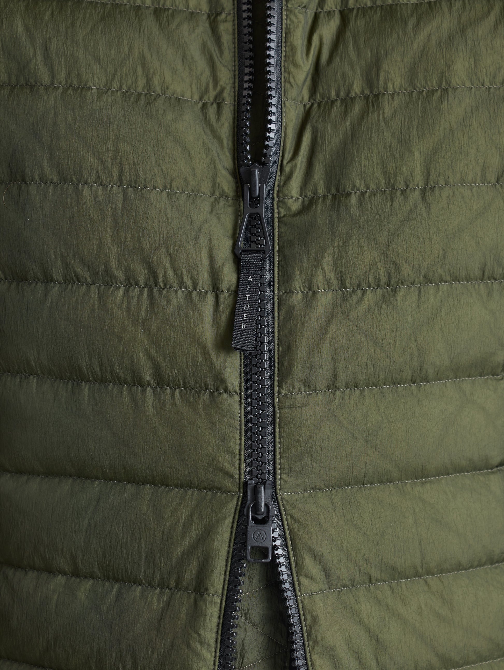 Closeup view of front zipper of Prospect Packable Down Jacket in Forest Green from AETHER Apparel.