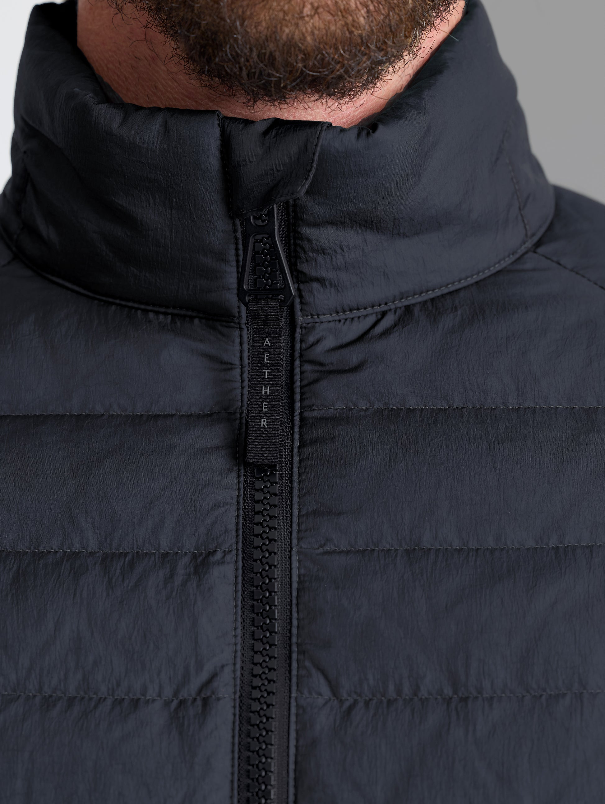 Closeup view of collar of Prospect Packable Down Jacket in Onyx Black from AETHER Apparel.