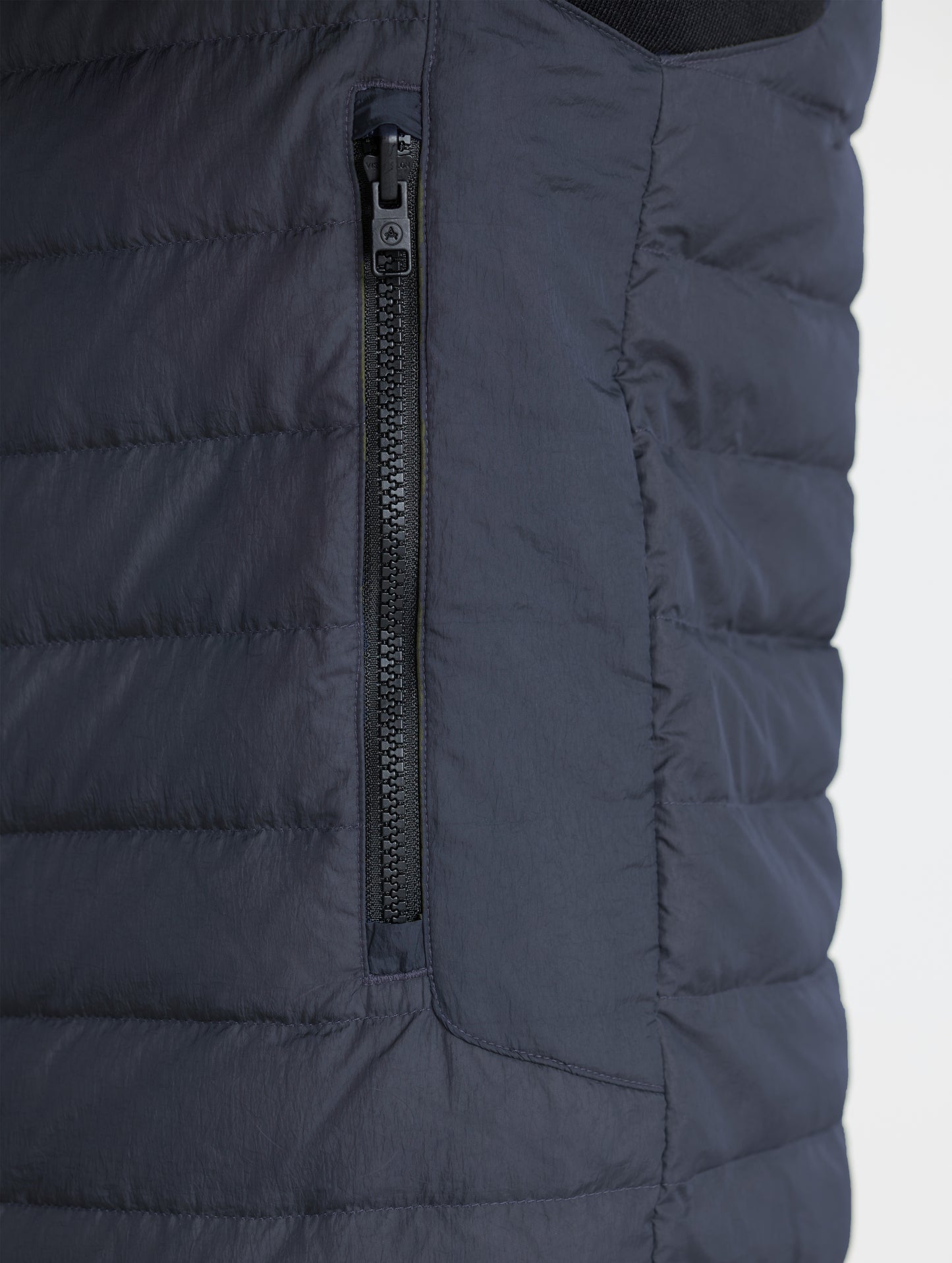Closeup view of left zipped hand pocket of Prospect Packable Down Jacket in Onyx Black from AETHER Apparel.