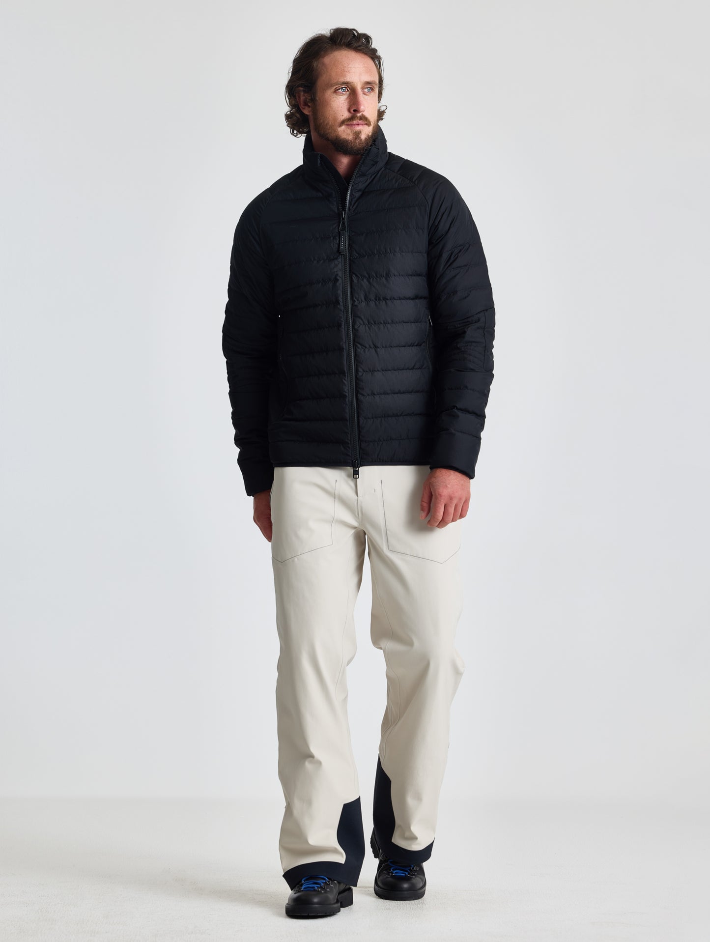 Full body view of man wearing Prospect Packable Down Jacket in Onyx Black from AETHER Apparel.