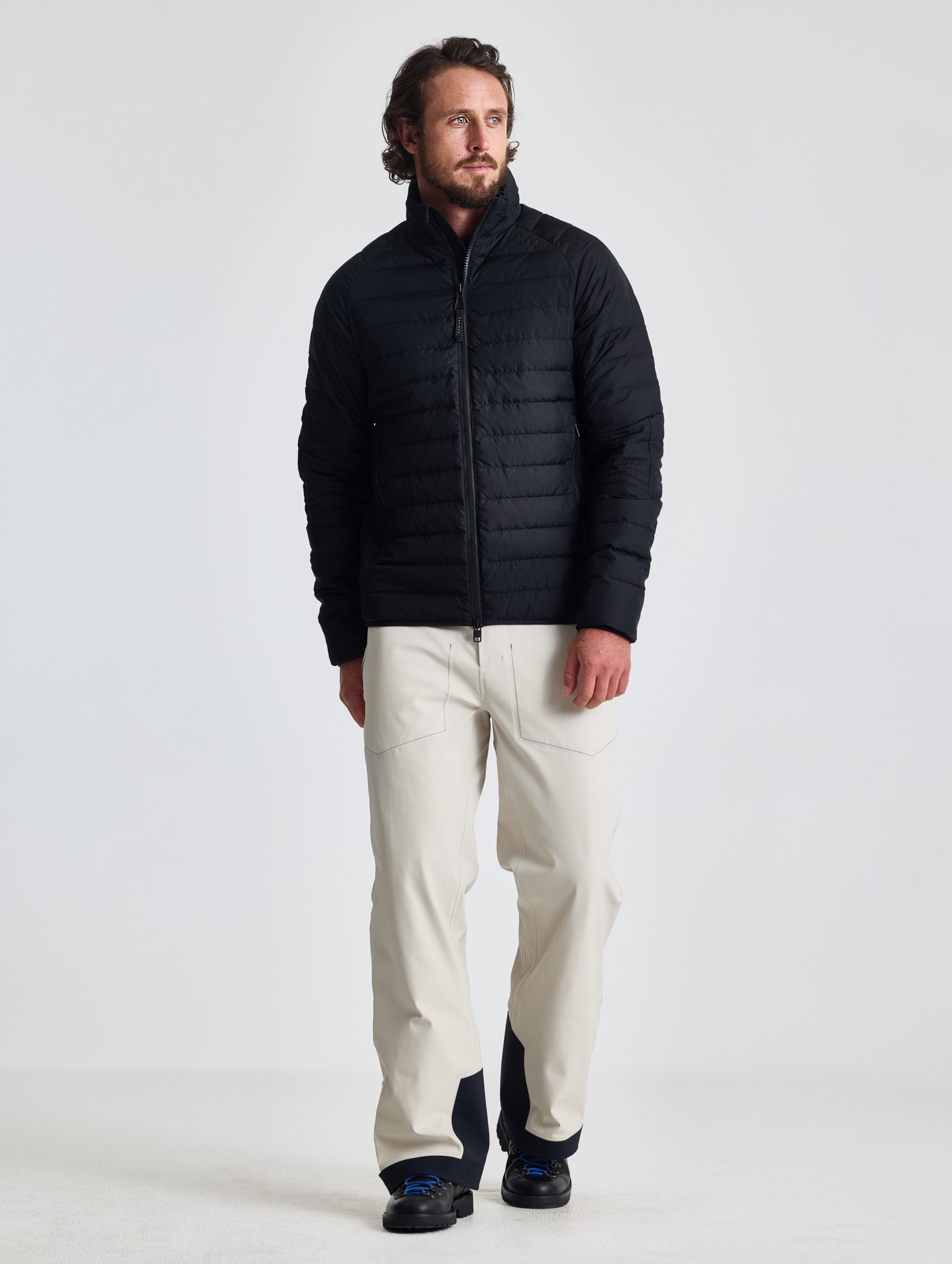 Full body view of man wearing Prospect Packable Down Jacket in Onyx Black from AETHER Apparel.