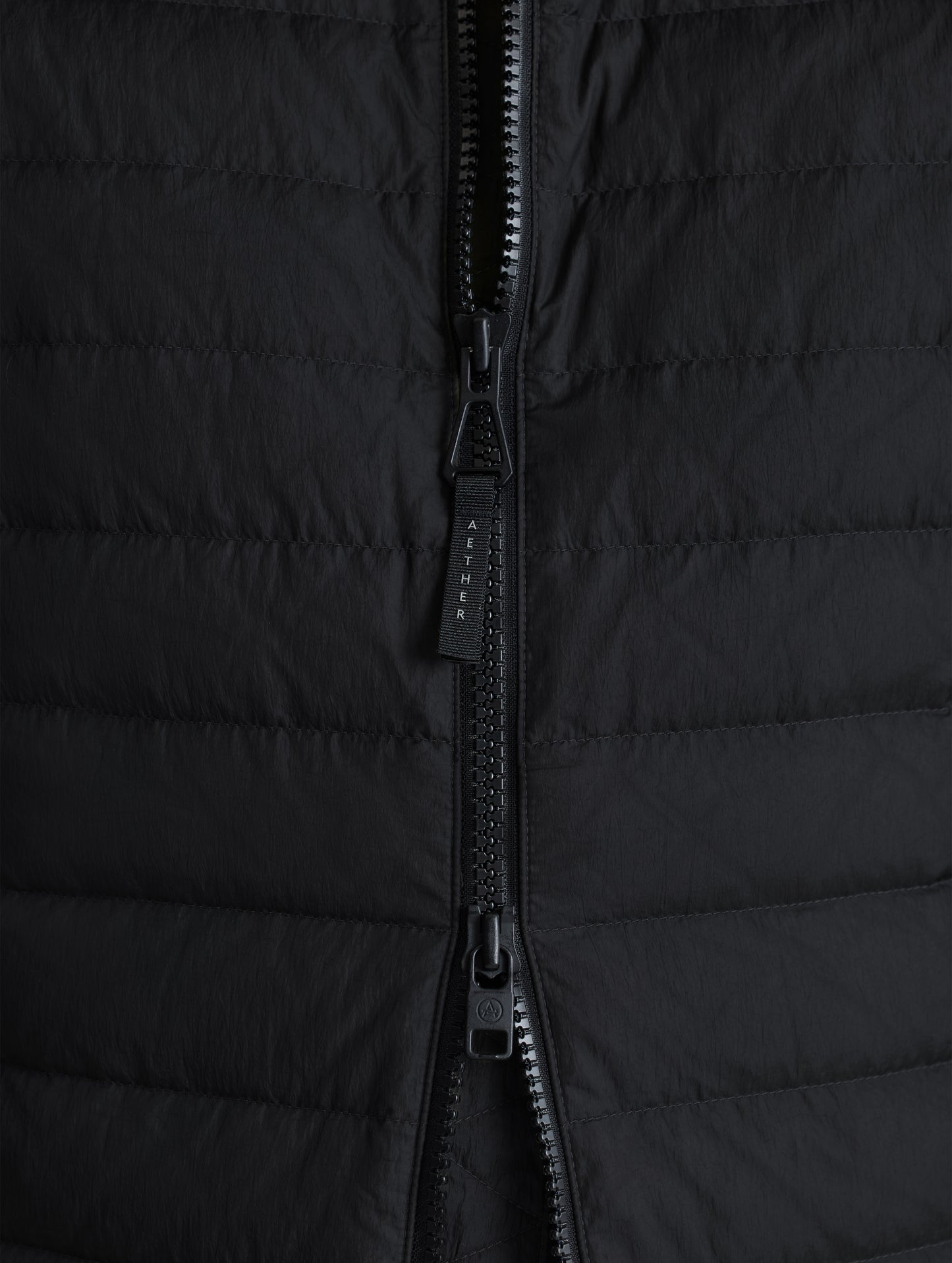 Closeup view of center front zipper of Prospect Packable Down Jacket in Onyx Black from AETHER Apparel.
