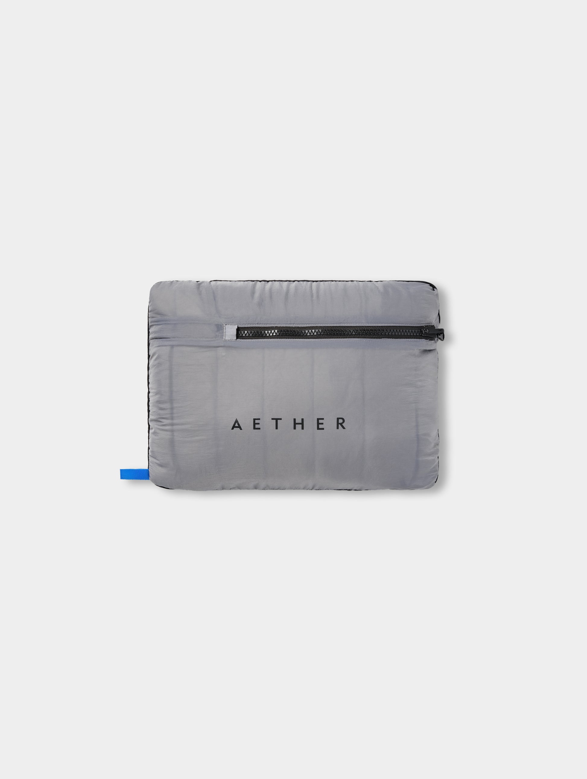 View of the Prospect Packable Down Jacket in Sky Grey from AETHER Apparel stuffed and packed into its own pocket. 