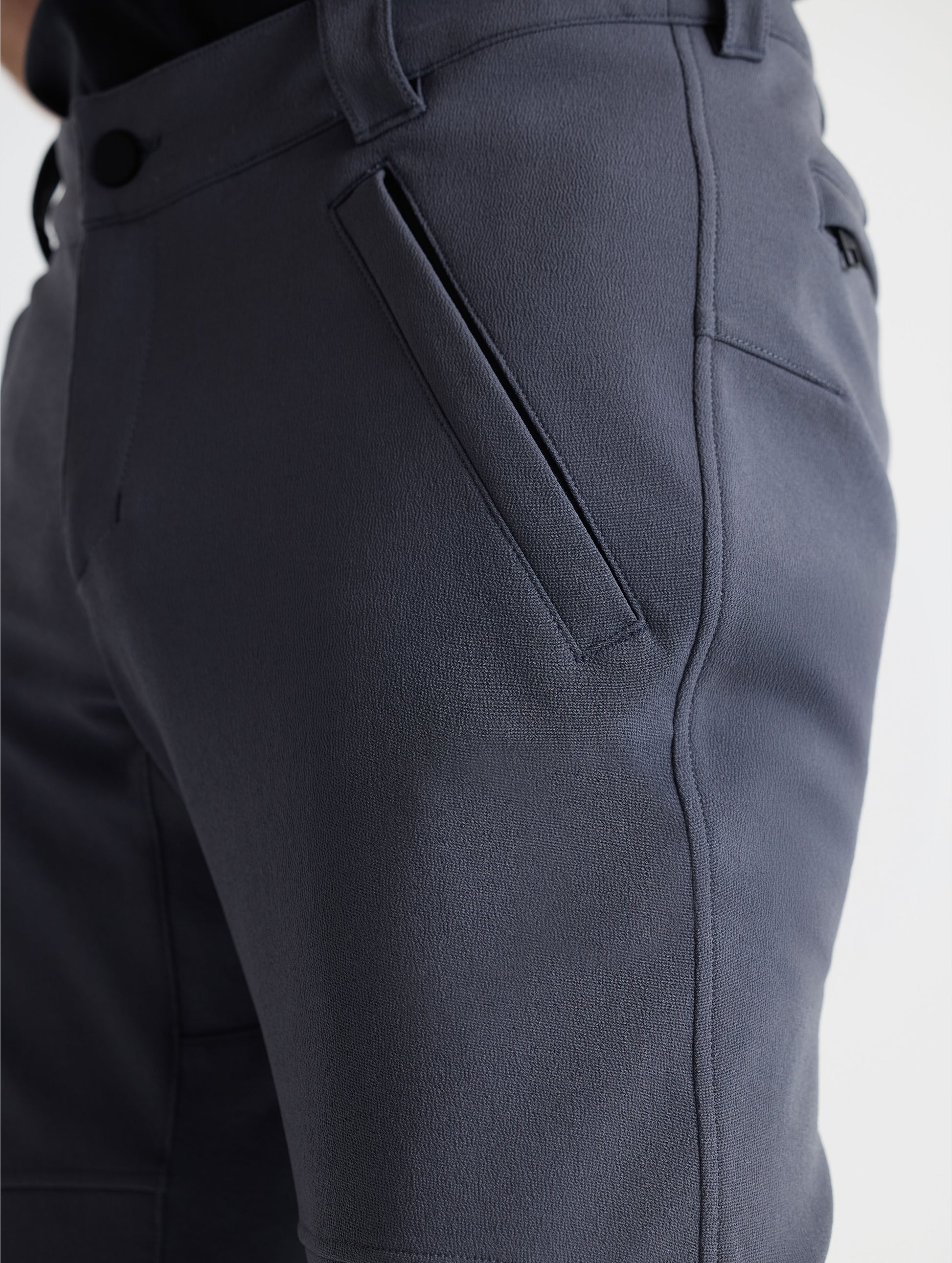 Closeup detailed view of one of the angled single welt zippered hand pockets on the Ramble Pant 3.0 in Graphite from AETHER Apparel. 