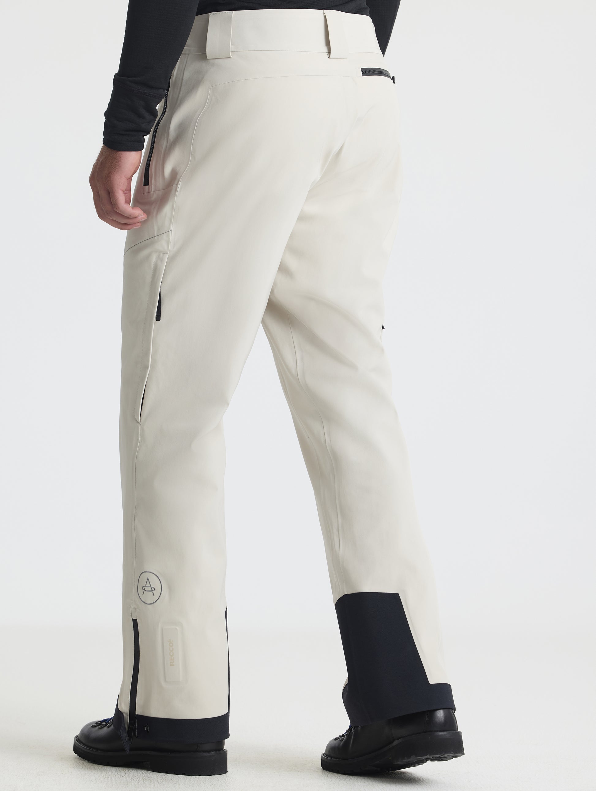Rear angled lower-body view of man wearing the Ridge Insulated Snow Pant in Bone from AETHER Apparel.