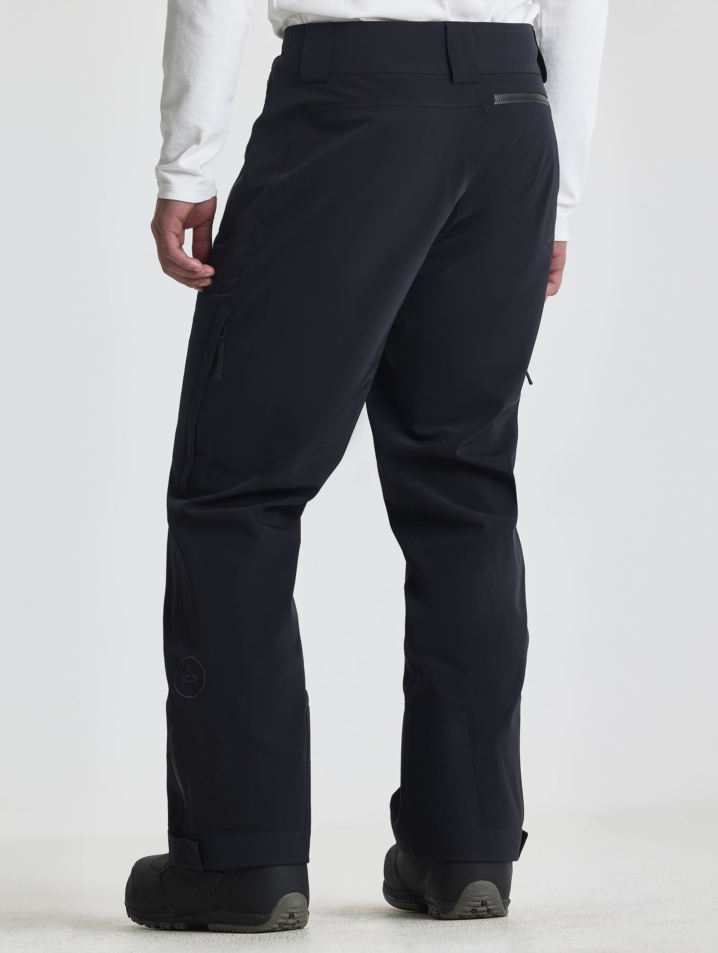 Rear angled lower-body view of man wearing the Ridge Insulated Snow Pant in Onyx Black from AETHER Apparel.