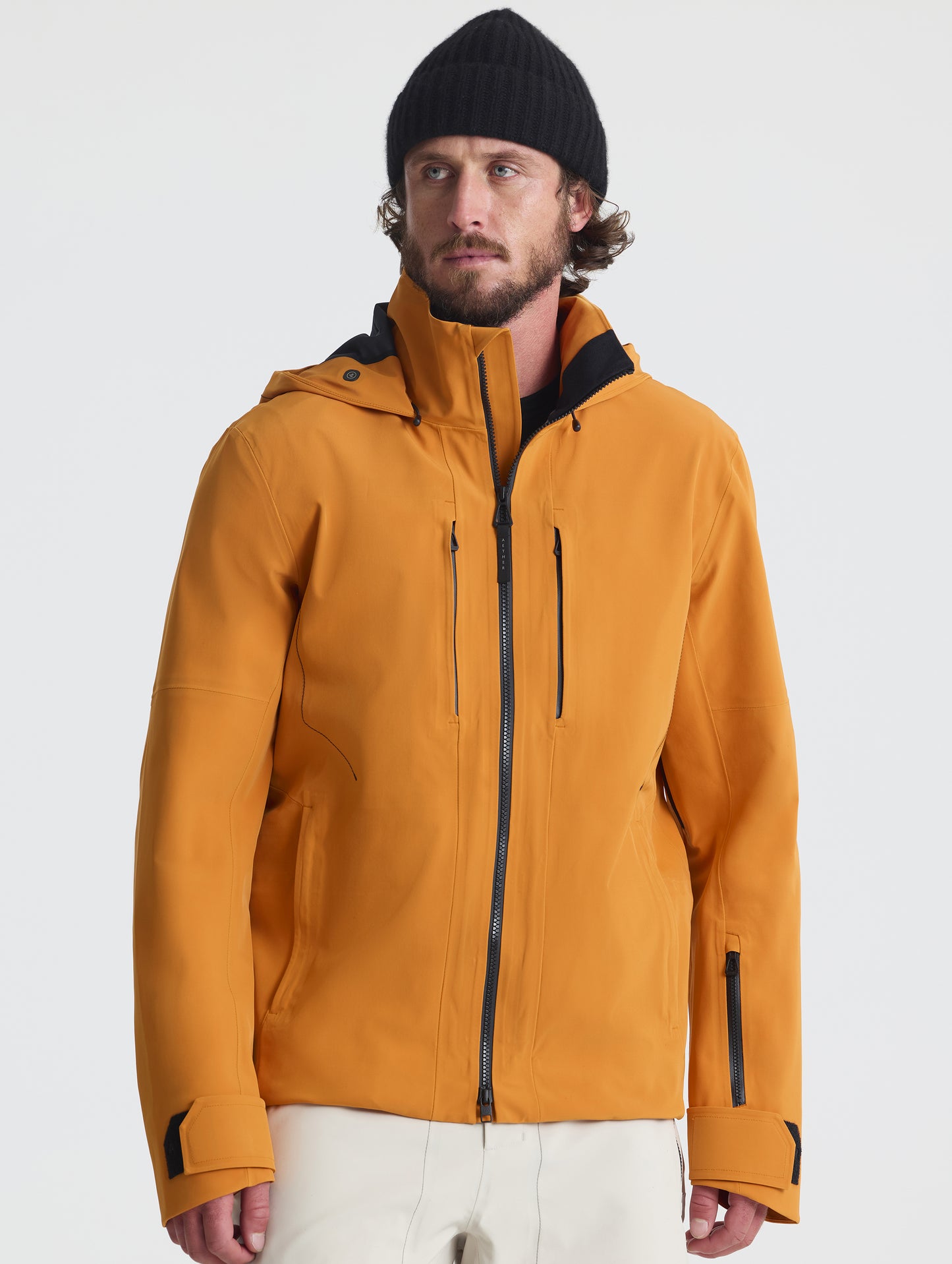 Front upper-body view of man wearing the Ridge Snow-Shell Jacket in Autumn Orange from AETHER Apparel.