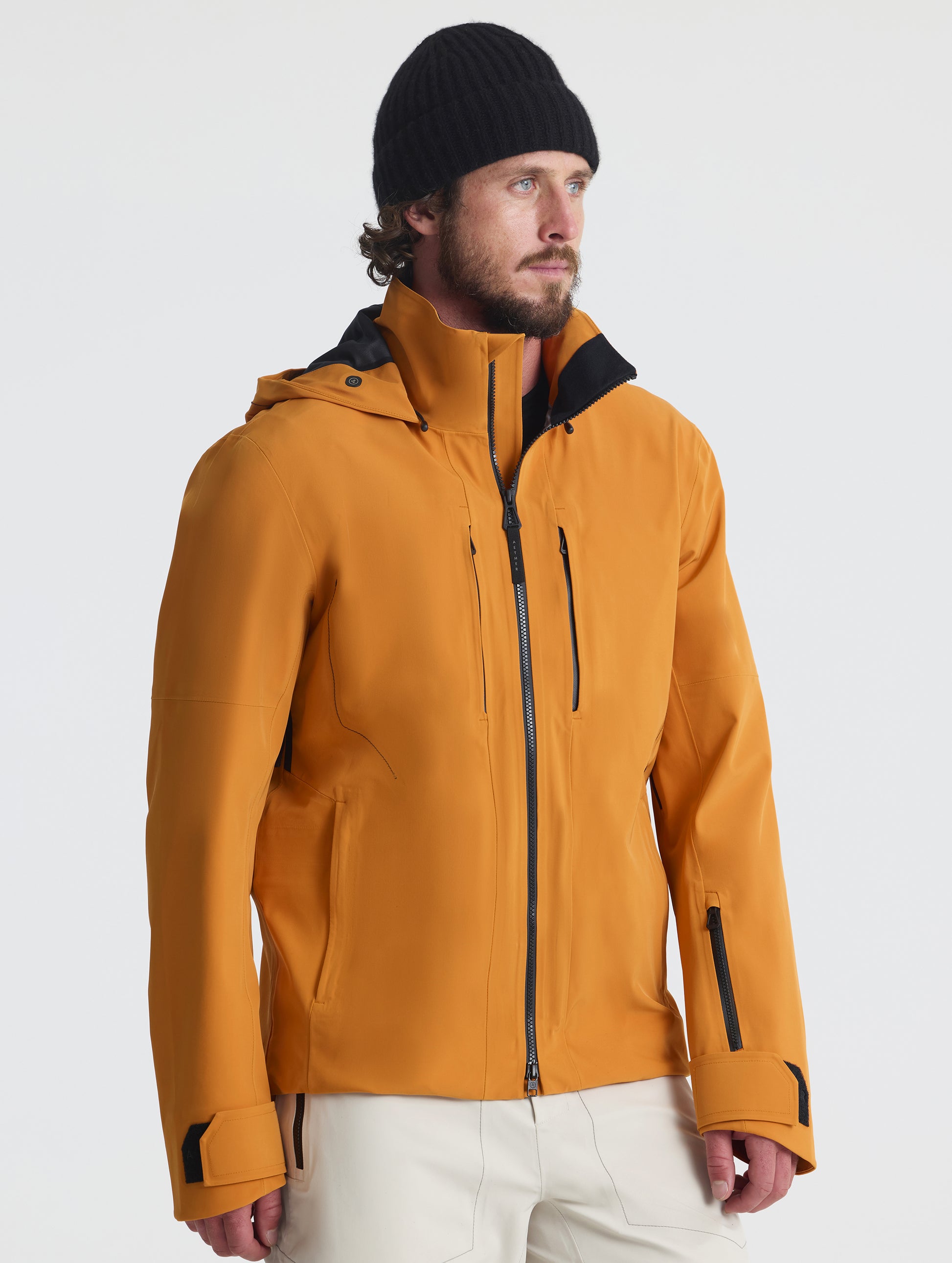 Front angled upper-body view of man wearing the Ridge Snow-Shell Jacket in Autumn Orange from AETHER Apparel.