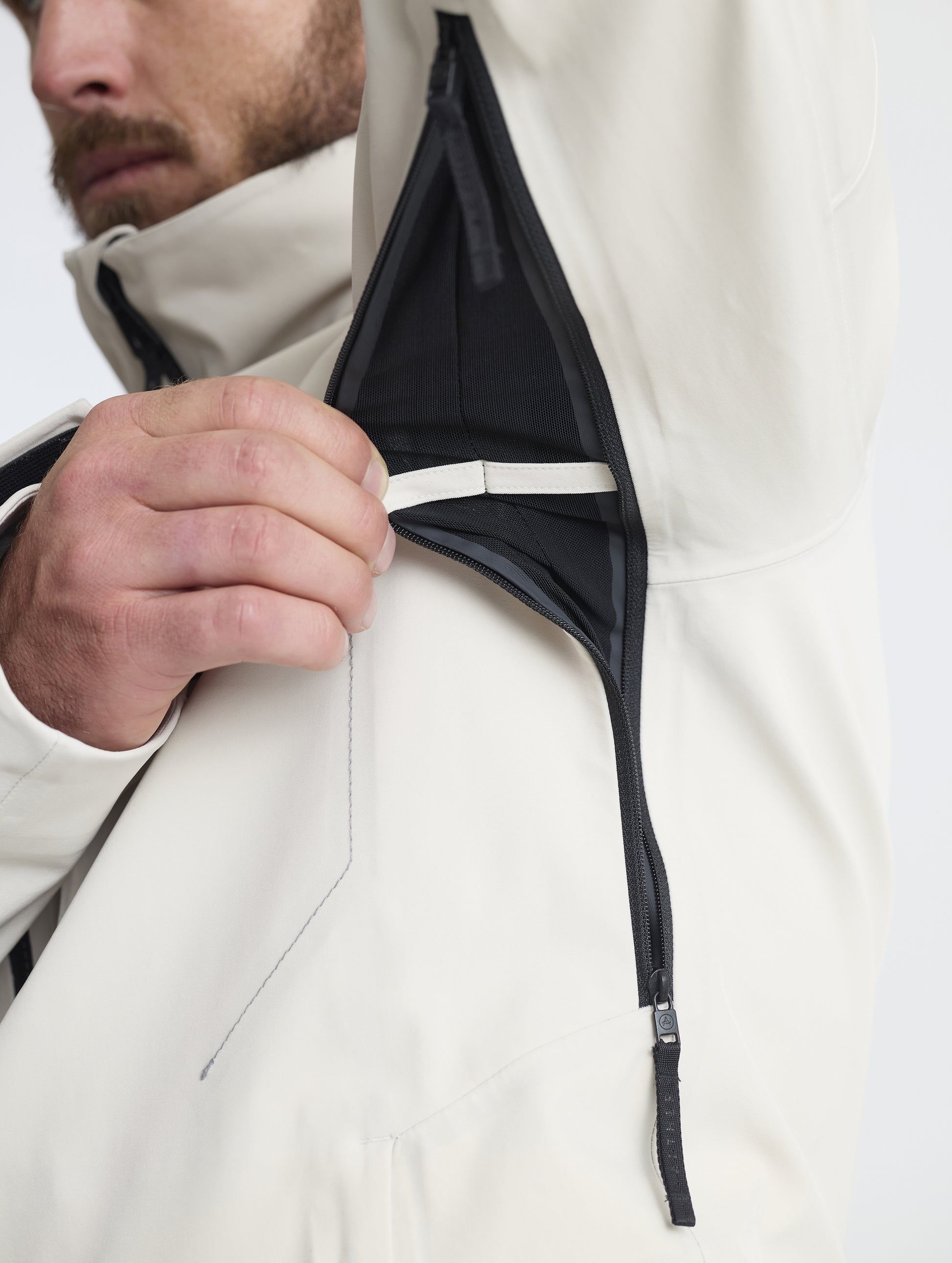 Closeup detailed view of the zipper-adjustable underarm ventilation ports on the Ridge Snow-Shell Jacket in Bone from AETHER Apparel.