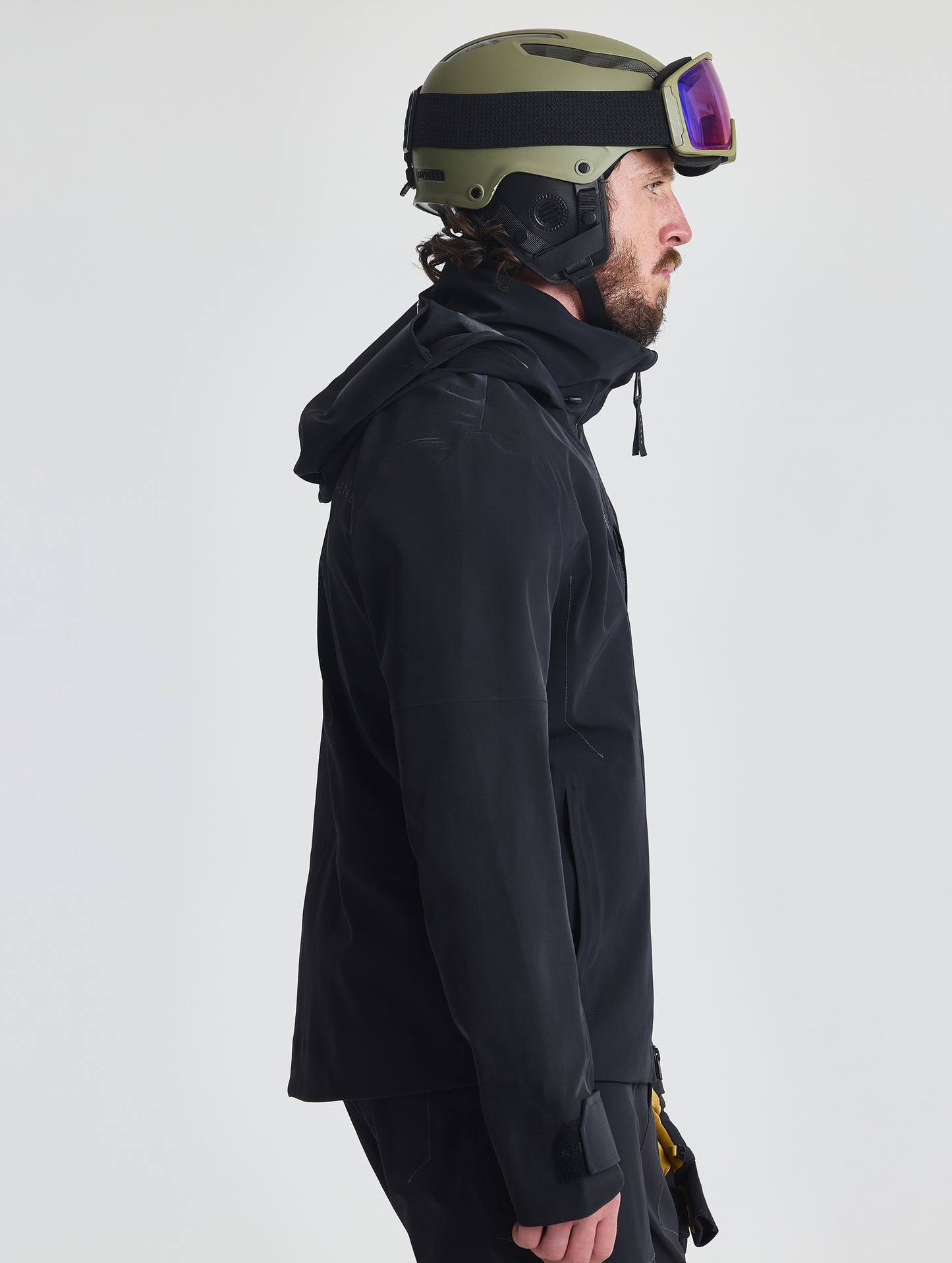 Side profile upper-body view of man wearing the Ridge Snow-Shell Jacket in Onyx Black from AETHER Apparel.