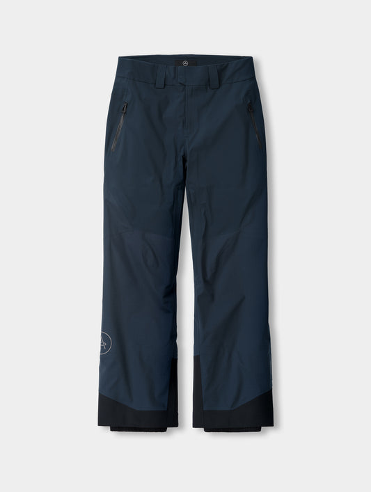 Flat lay of the men’s Silance Snow-Shell Pant in Total Eclipse dark blue from AETHER Apparel, with zippered thigh pockets and black reinforced cuffs.