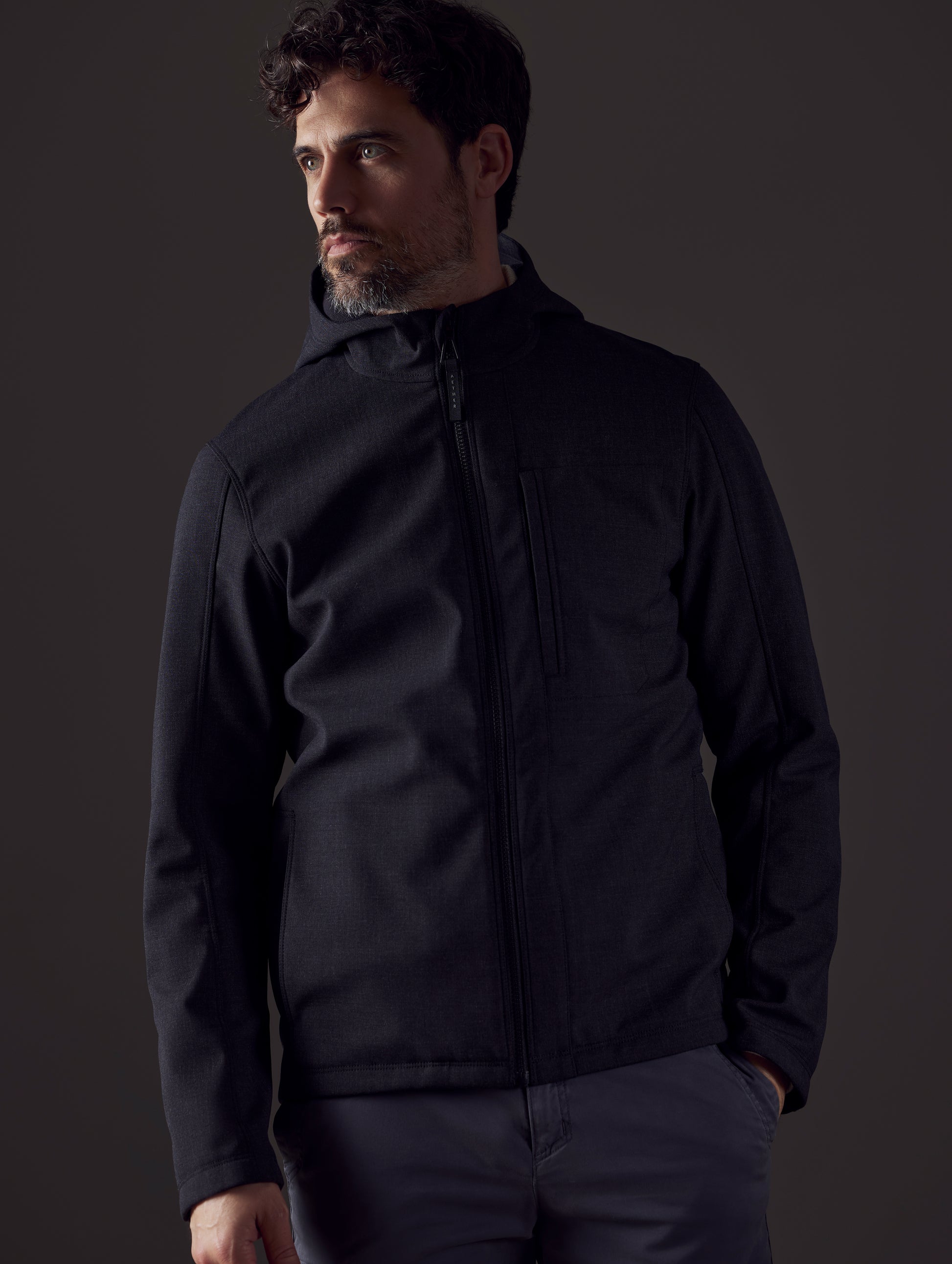 Man wearing dark grey technical jacket from AETHER Apparel