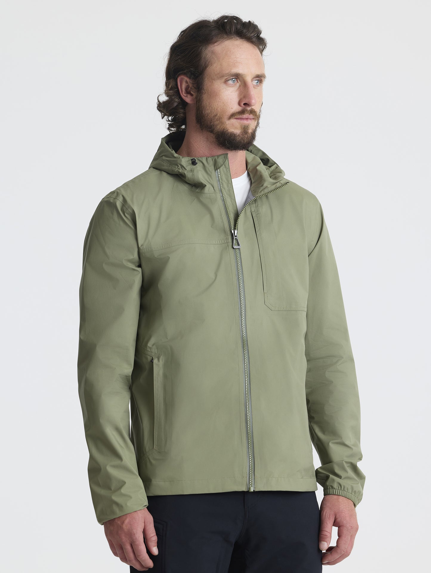 Front 3/4 view of man wearing Storm All-Weather Jacket in Fern Green from AETHER Apparel.