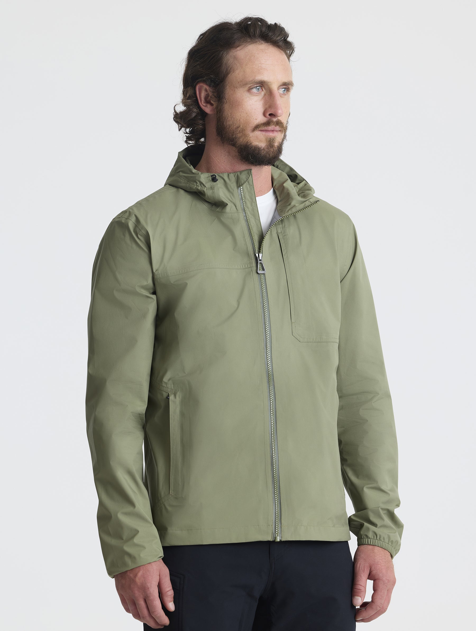 Front 3/4 view of man wearing Storm All-Weather Jacket in Fern Green from AETHER Apparel.