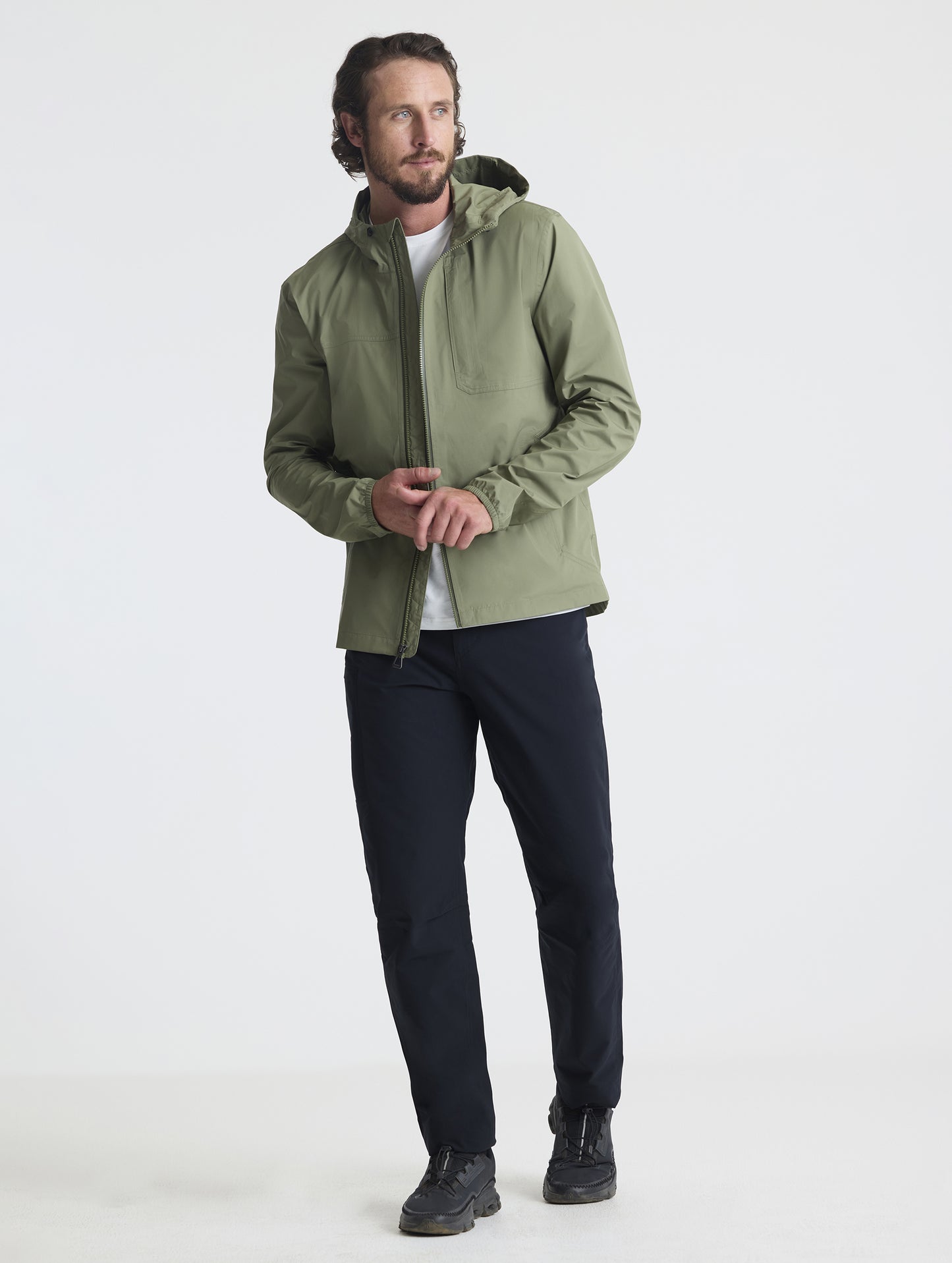 Full body view of man wearing Storm All-Weather Jacket in Fern Green from AETHER Apparel.