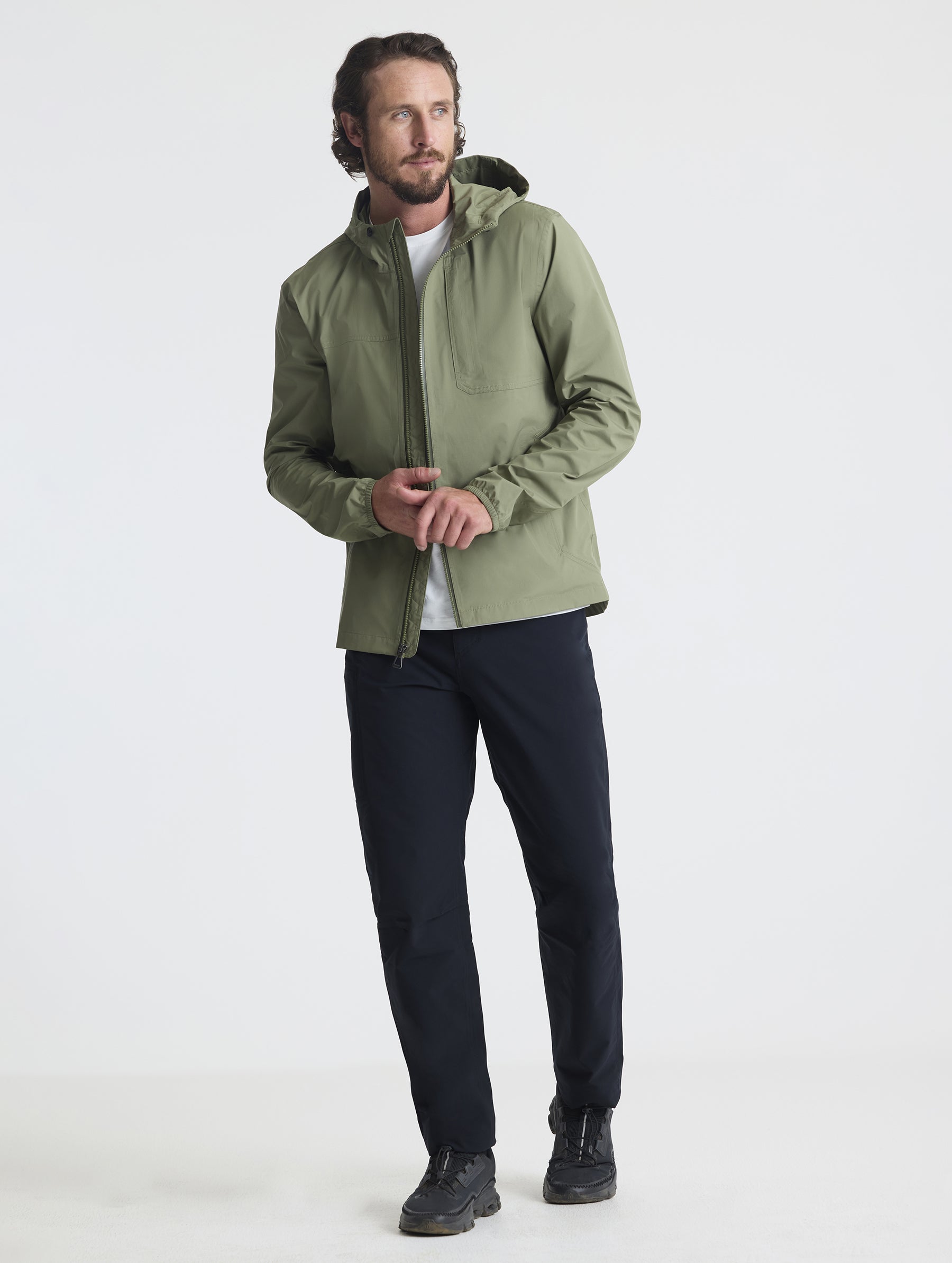 Full body view of man wearing Storm All-Weather Jacket in Fern Green from AETHER Apparel.