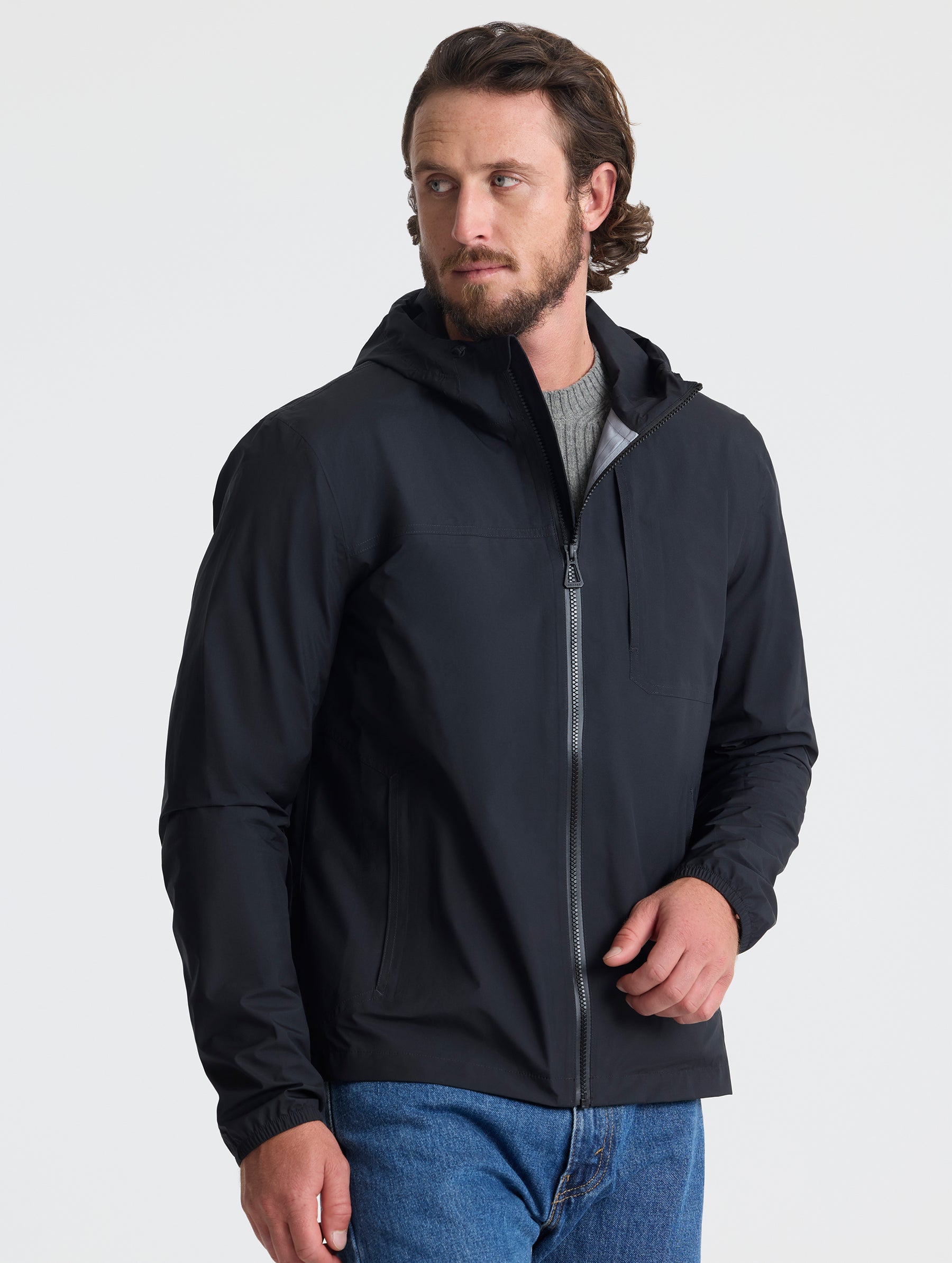 Front view of man wearing Storm All-Weather Jacket in Onyx Black from AETHER Apparel.