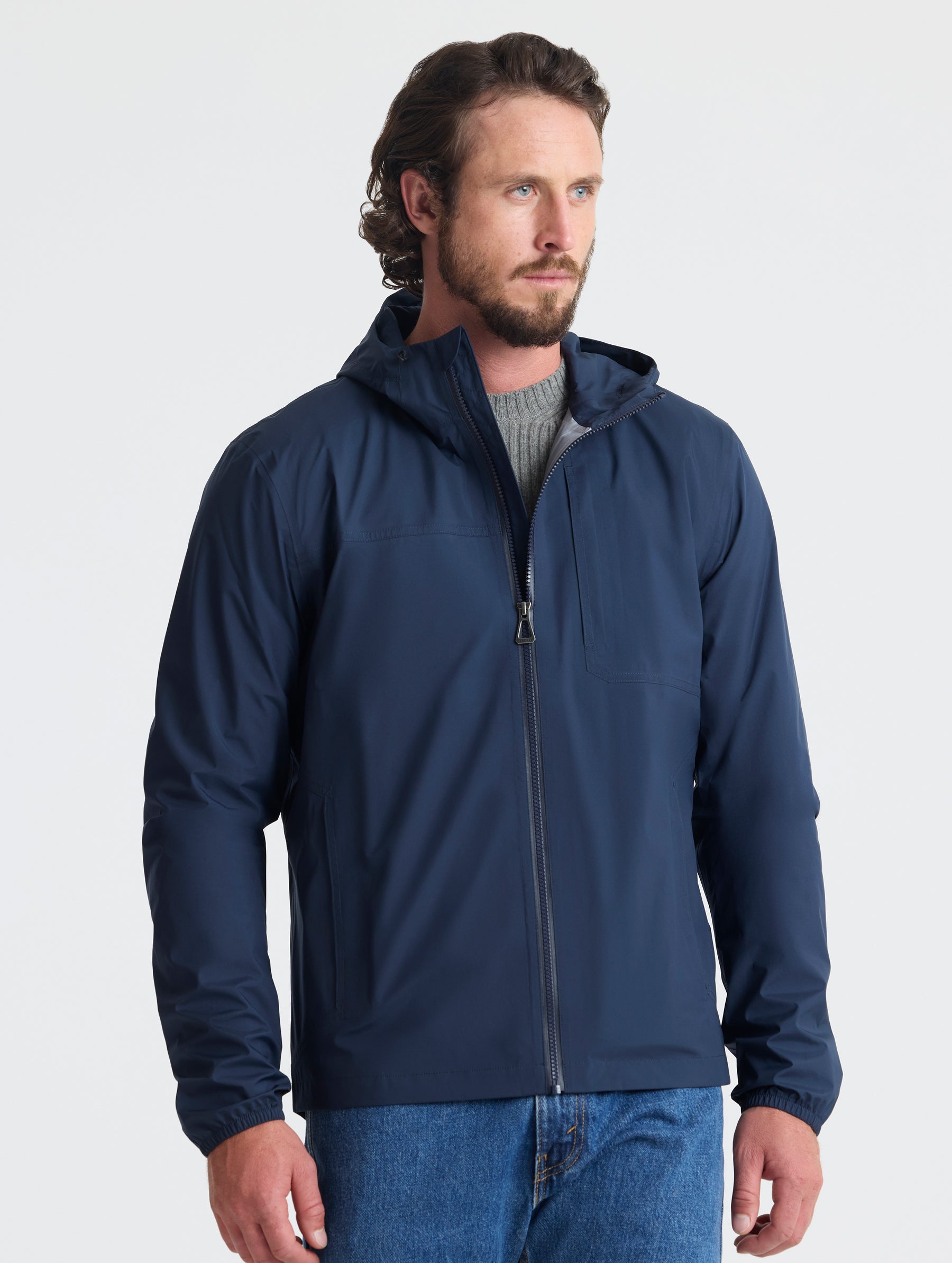 Front view of man wearing Storm All-Weather Jacket in Total Eclipse dark blue from AETHER Apparel.