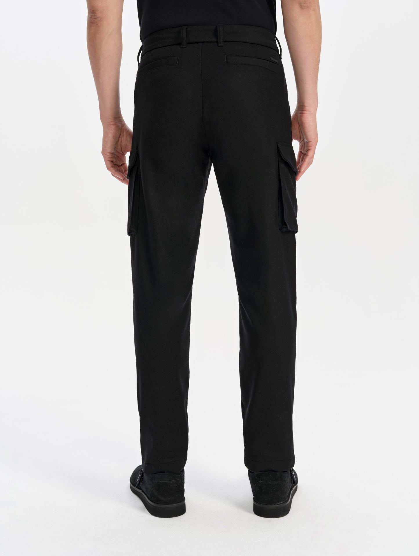 Rear lower-body view of man wearing the Strata Wool Pant in Onyx Black from AETHER Apparel.