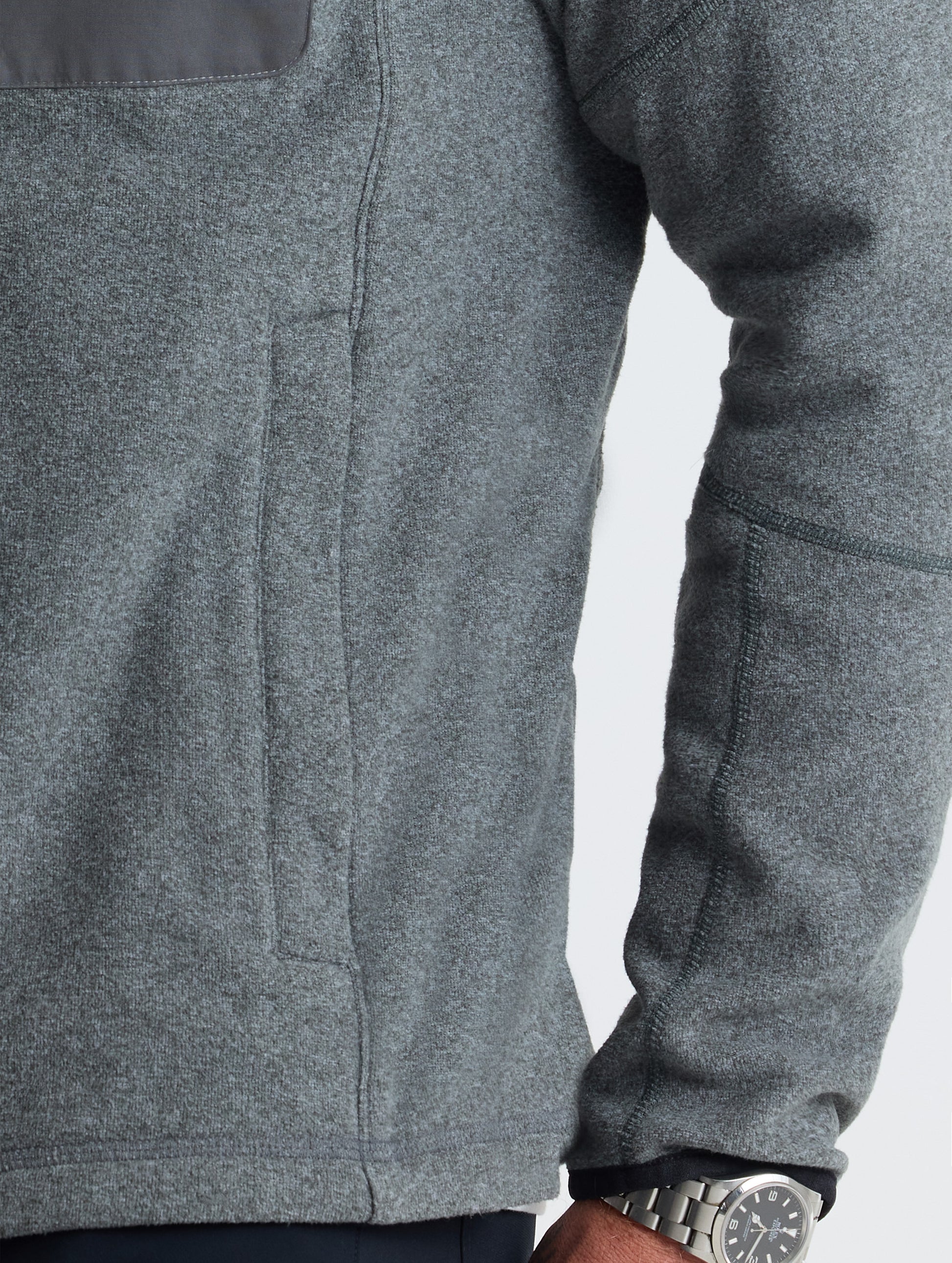 Closeup view of wearer's left hand pocket of Sutherlin Full-Zip in Charcoal Grey from AETHER Apparel.