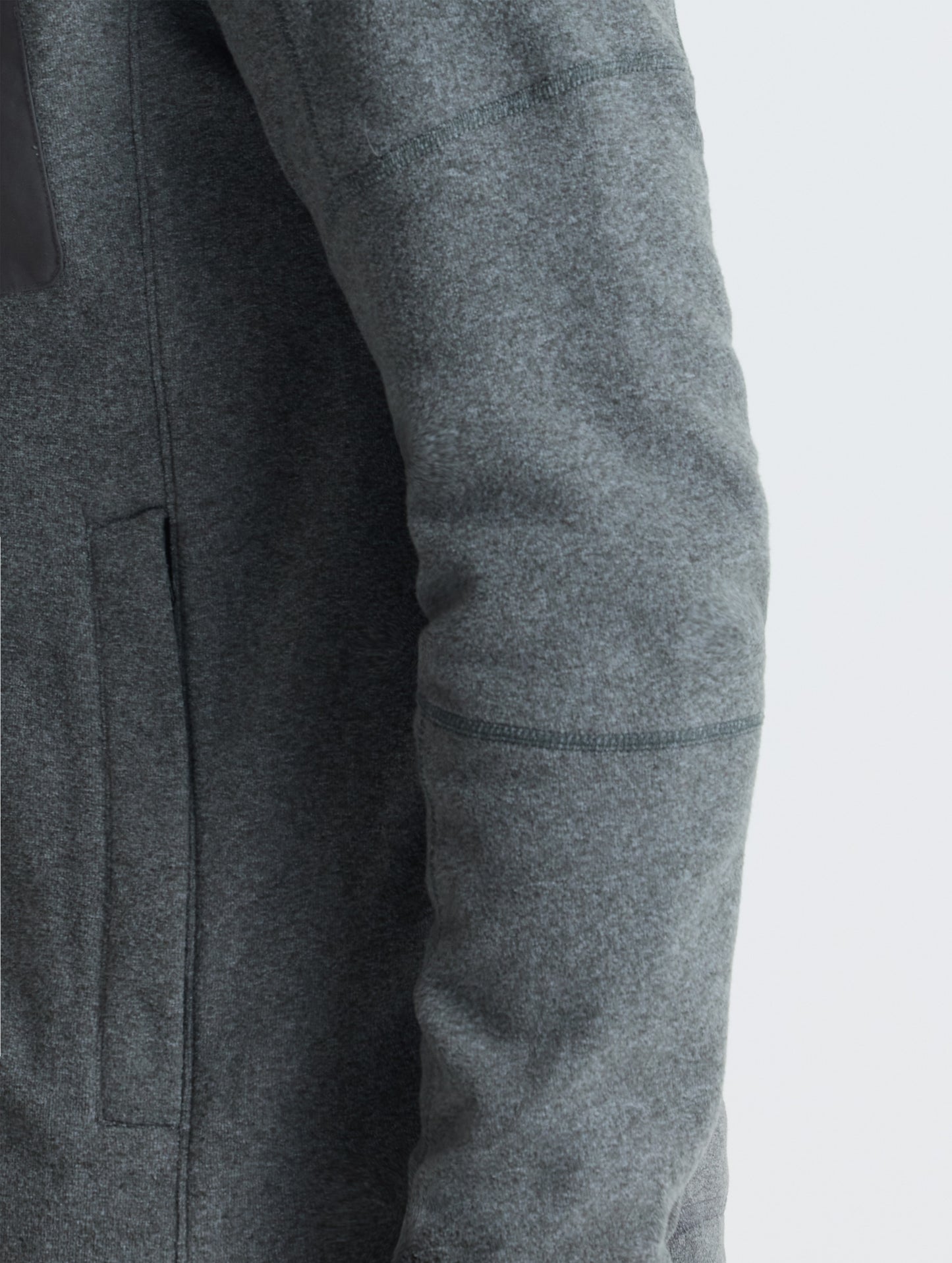 Closeup view of wearer's left sleeve of Sutherlin Full-Zip in Charcoal Grey from AETHER Apparel.