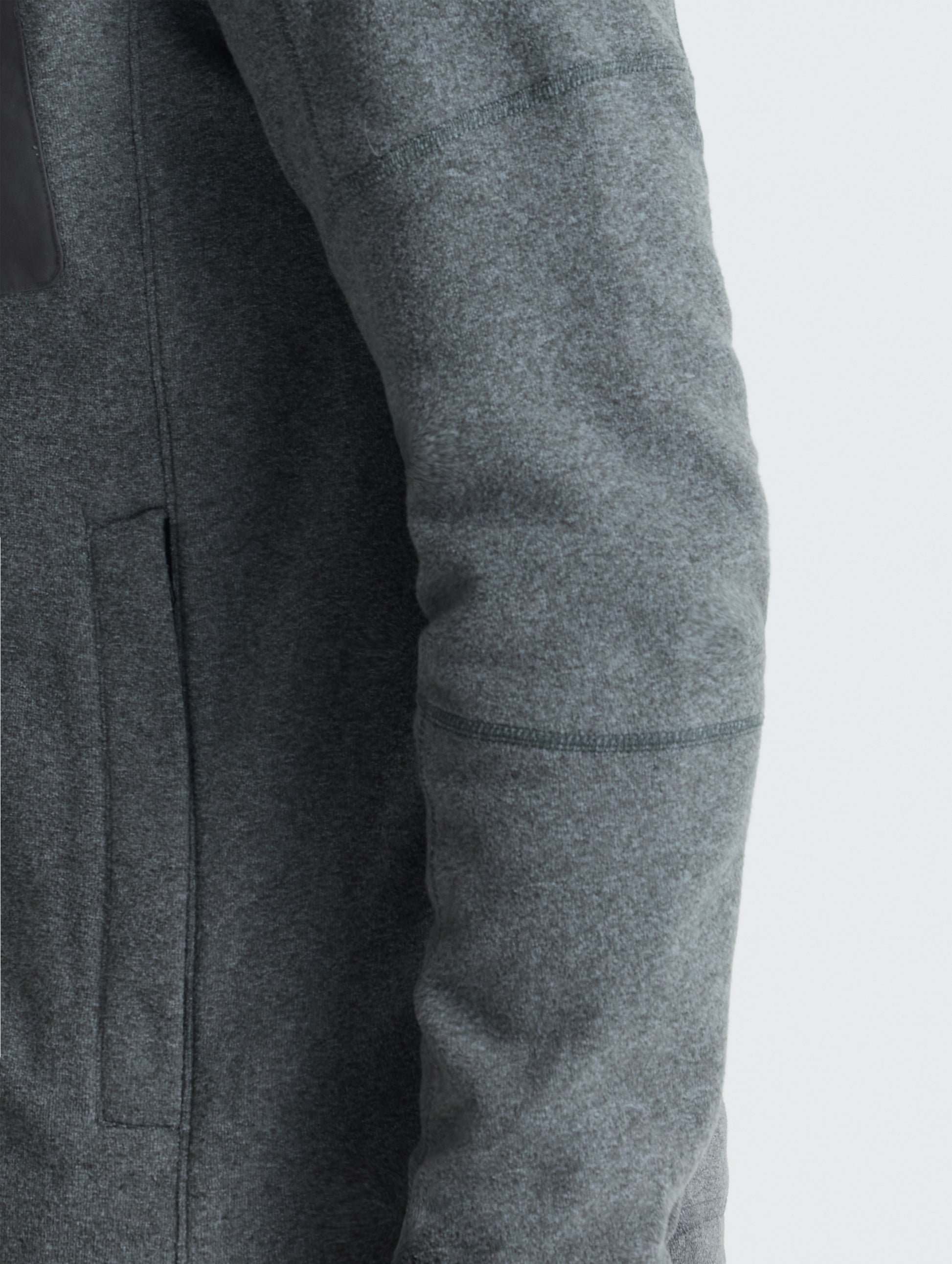 Closeup view of wearer's left sleeve of Sutherlin Full-Zip in Charcoal Grey from AETHER Apparel.