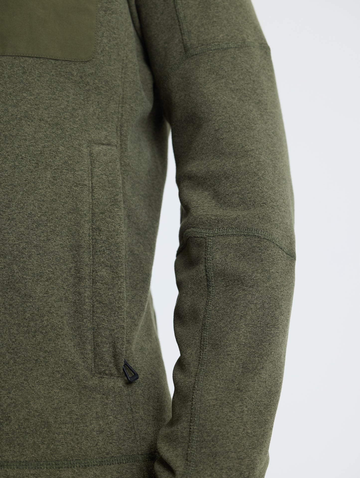 Closeup view of wearer's left hand pocket and sleeve of Sutherlin Full-Zip in Forest Green from AETHER Apparel.