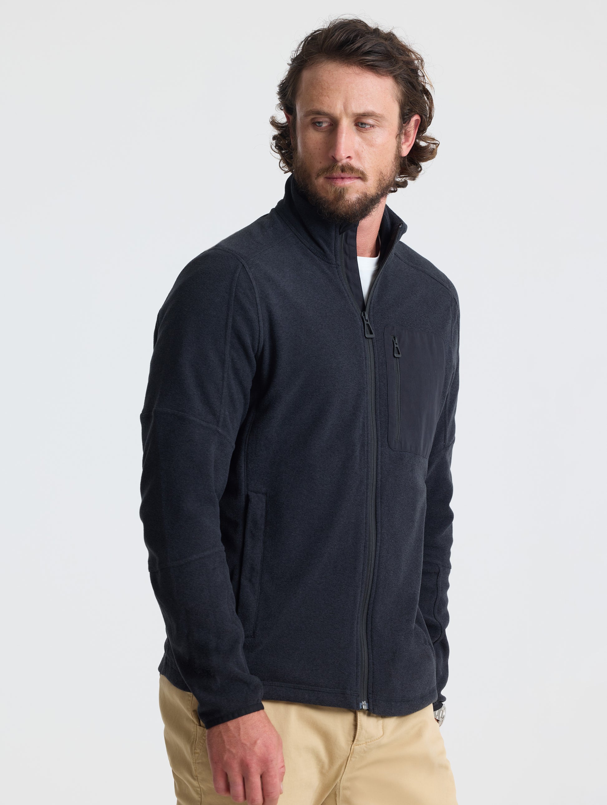Angled view of man wearing Sutherlin Full-Zip in Onyx Black from AETHER Apparel.
