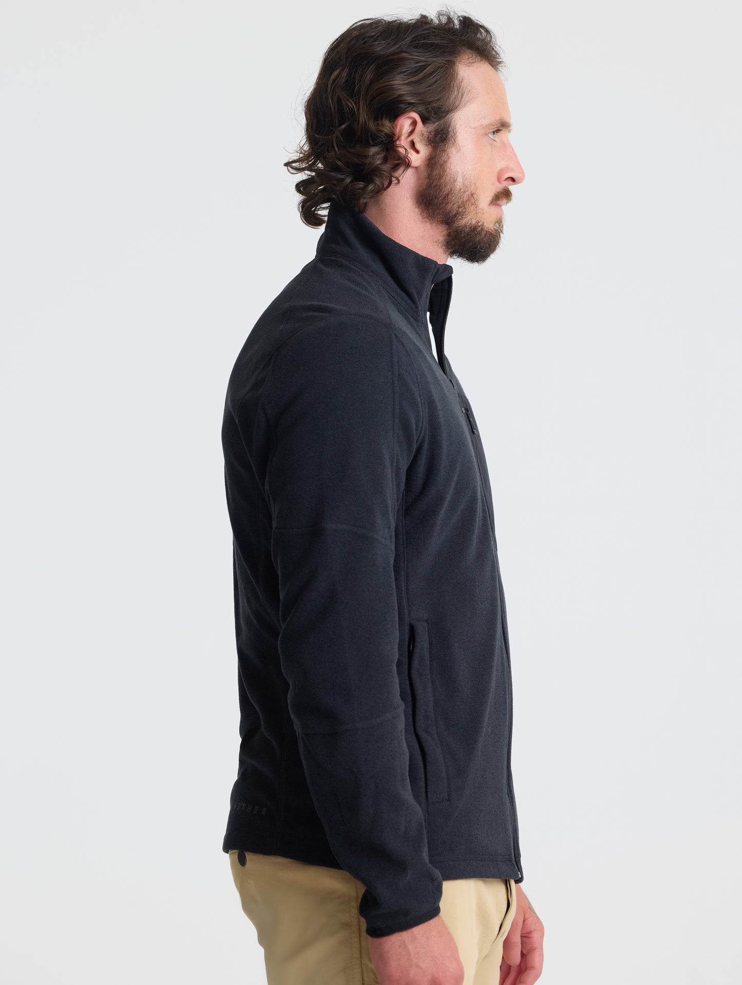 Right profile view of man wearing Sutherlin Full-Zip in Onyx Black from AETHER Apparel.