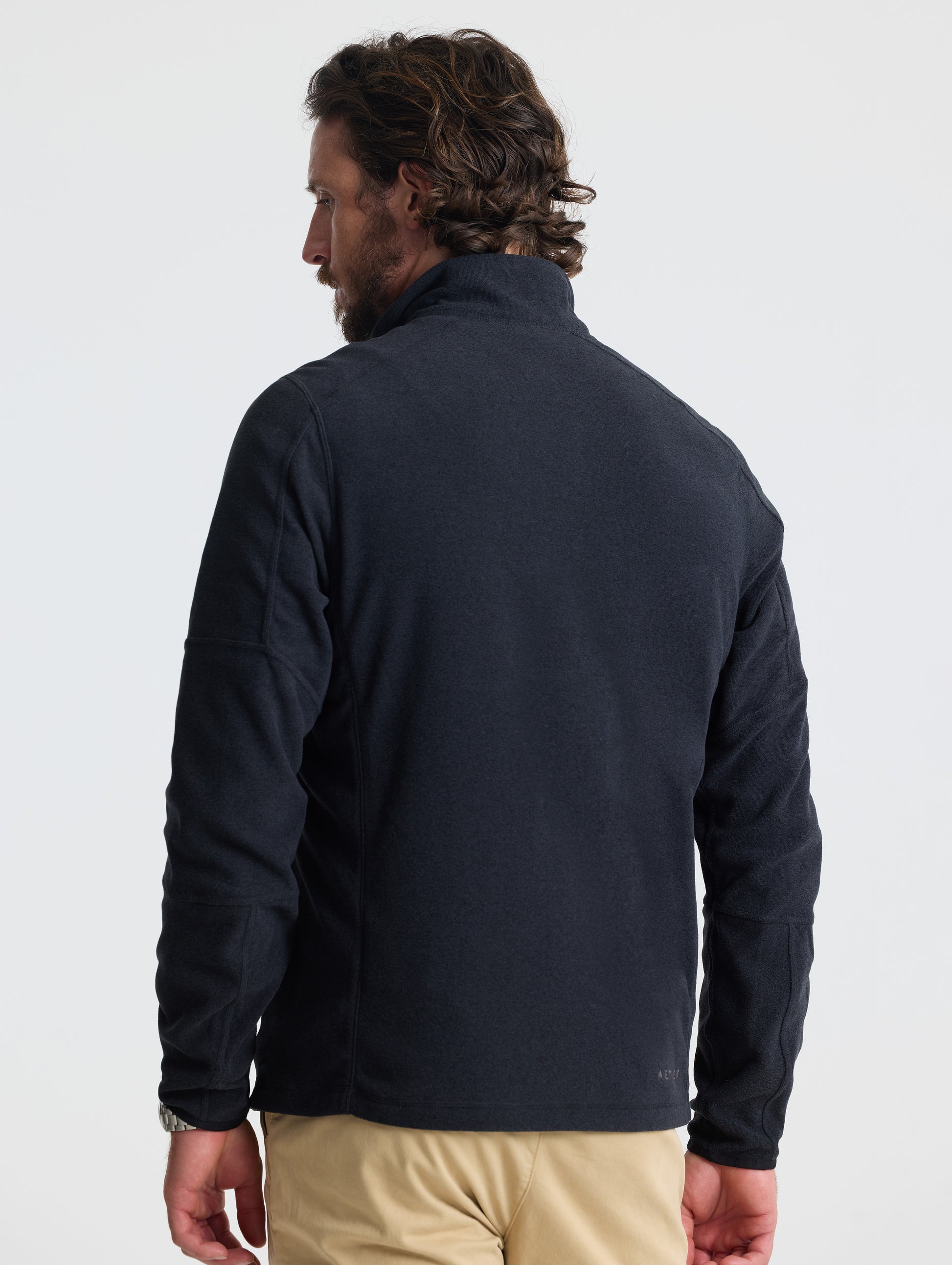 Rear view of man wearing Sutherlin Full-Zip in Onyx Black from AETHER Apparel.