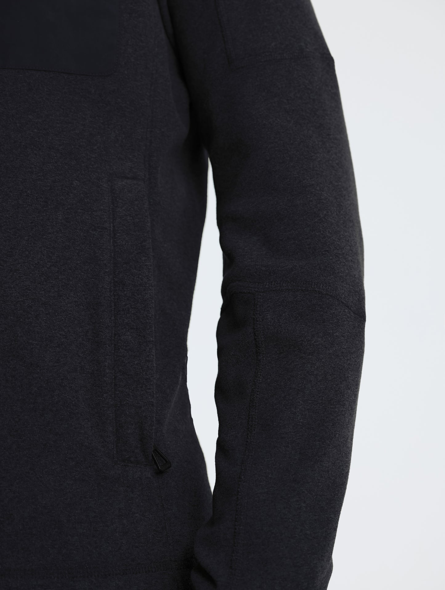 Closeup rear view of wearer's right sleeve of Sutherlin Full-Zip in Onyx Black from AETHER Apparel.