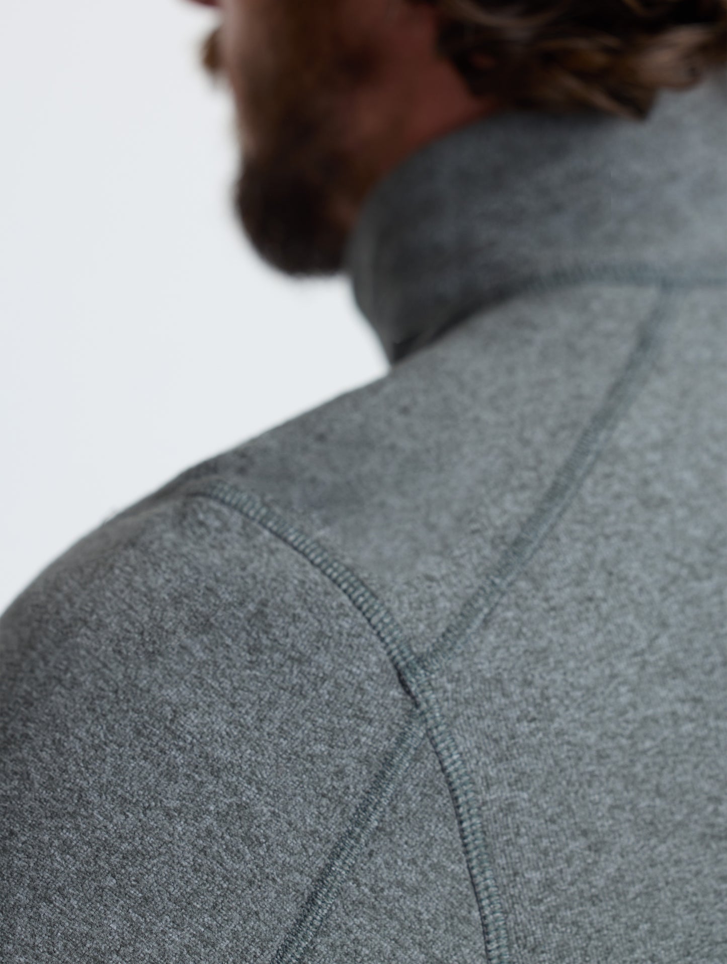 Closeup rear detail view of wearer's left shoulder of Sutherlin Half-Zip in Charcoal Heather from AETHER Apparel.