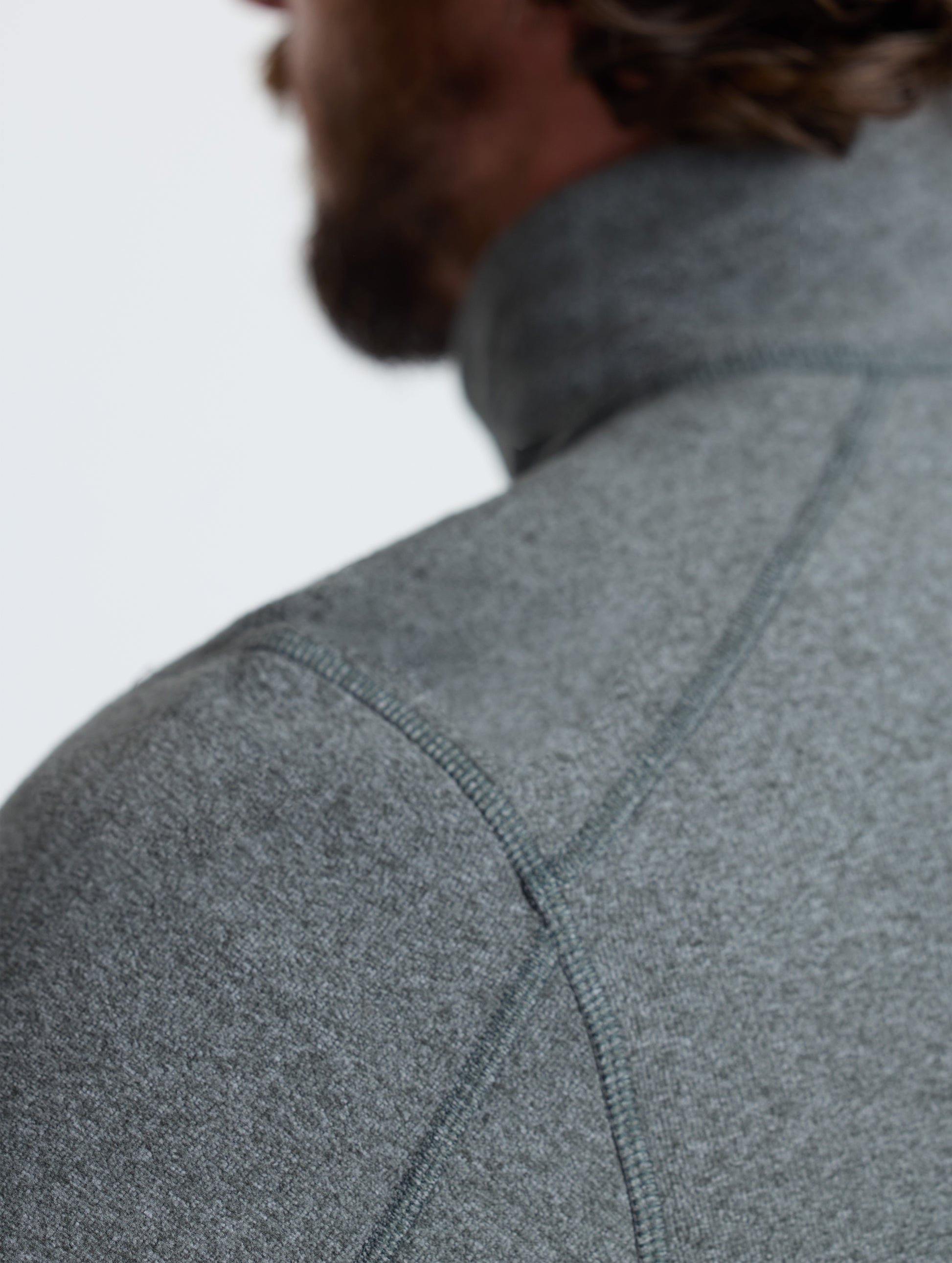 Closeup rear detail view of wearer's left shoulder of Sutherlin Half-Zip in Charcoal Heather from AETHER Apparel.